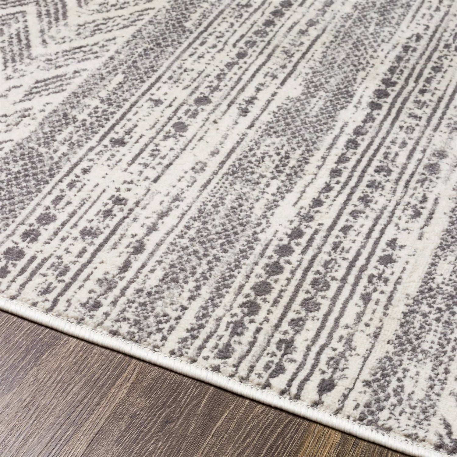 6.6-ft. x 9-ft. Grey Ivory Chevron Stripe Geometric Boho Style Area Rug with distressed vintage design on a wooden floor