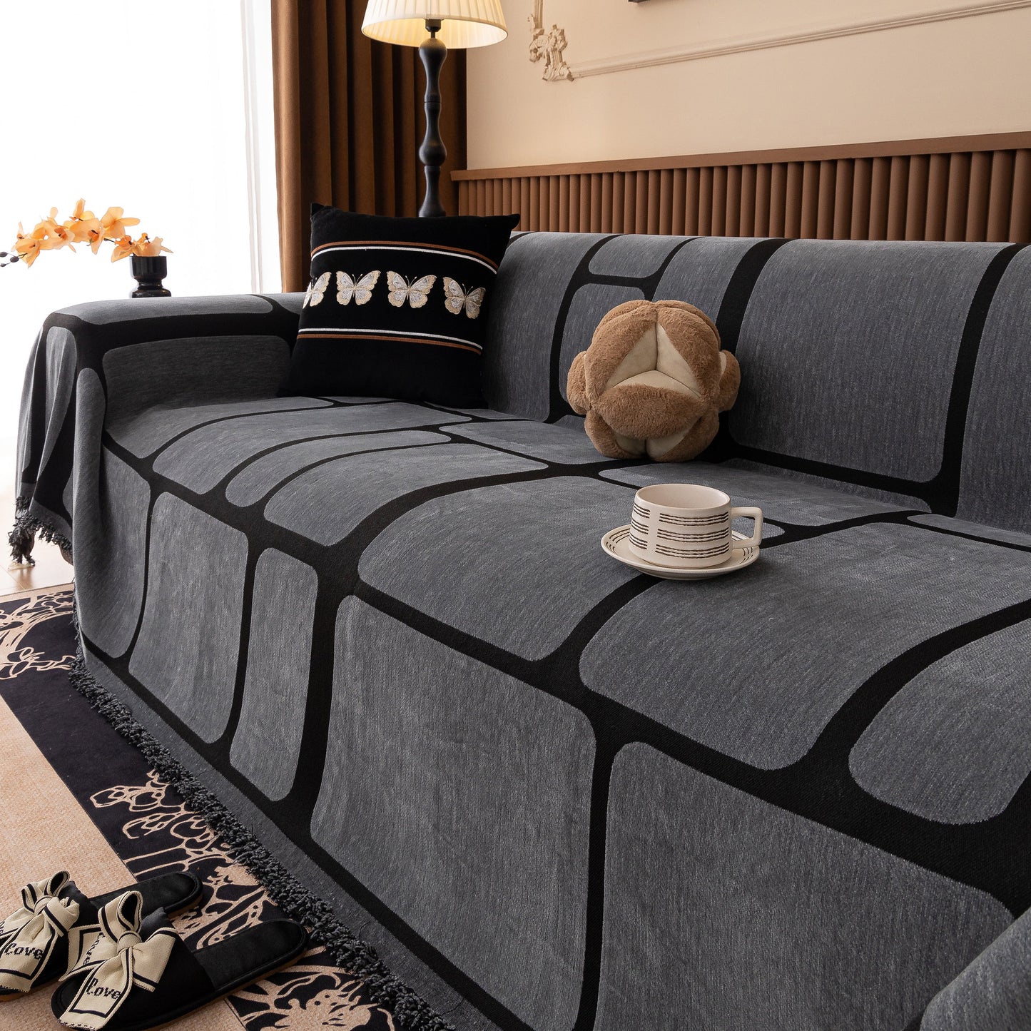 Modern Geometric Sofa Cover Decorative Couch Throw Blanket Furniture Protector in grey with tassel edges on a living room sofa