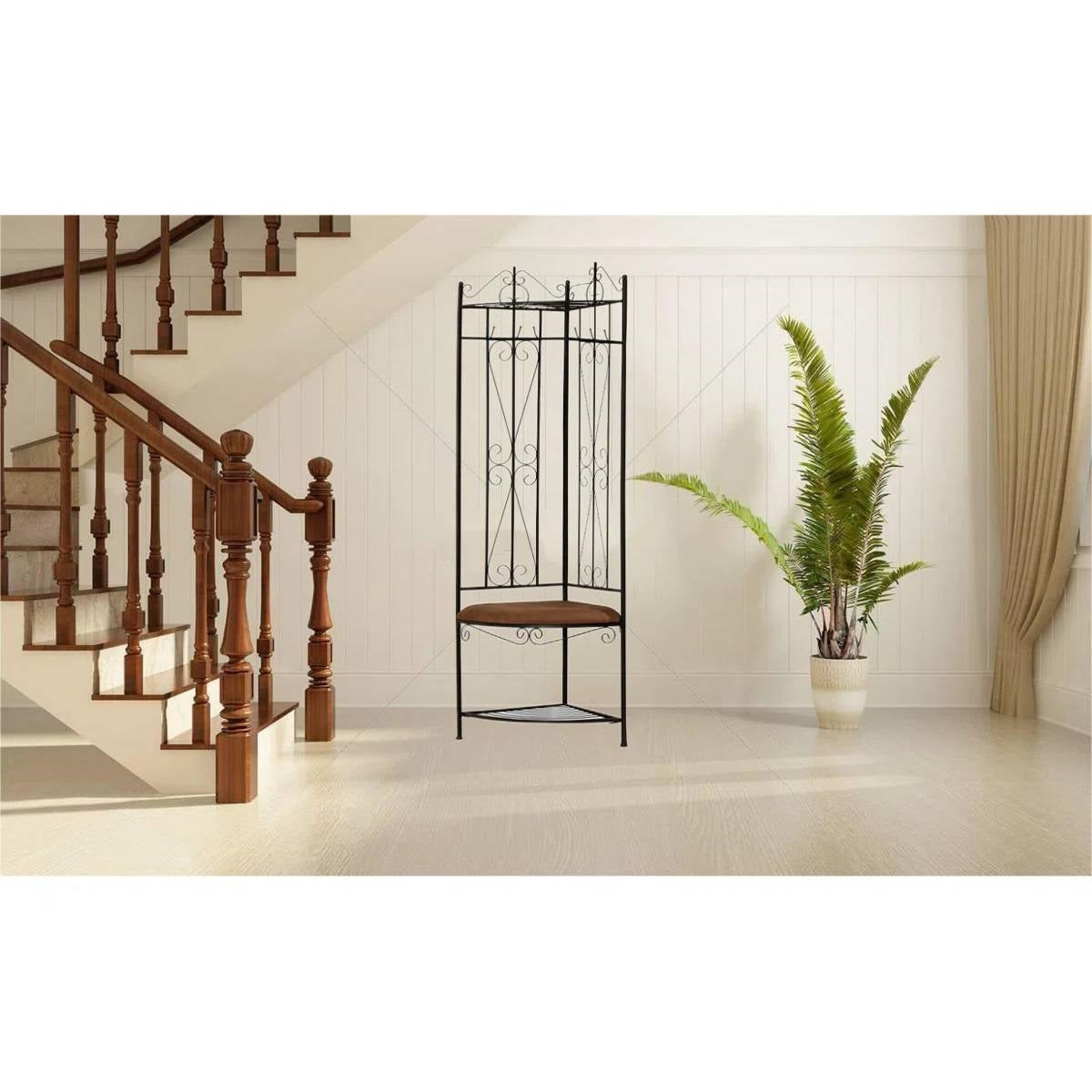 Black Metal Scrolling Corner Hall Tree Coat Rack Storage Bench in a stylish entryway with a plant and wooden staircase.