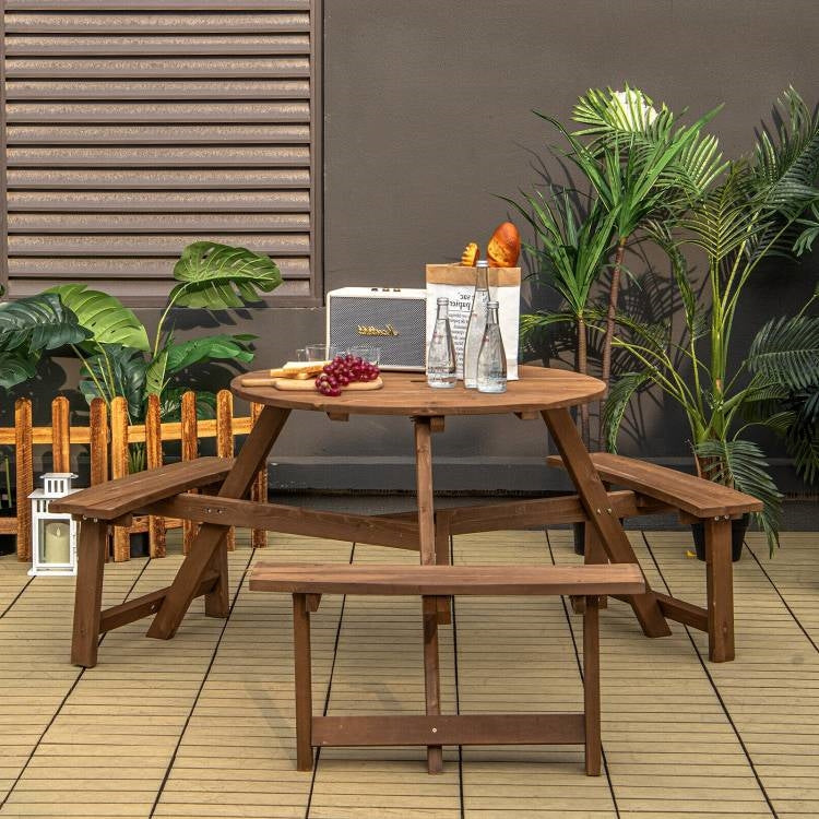 Outdoor Solid Wood Round Picnic Table Set with Umbrella Hole and 3 Benches on a deck, surrounded by plants.