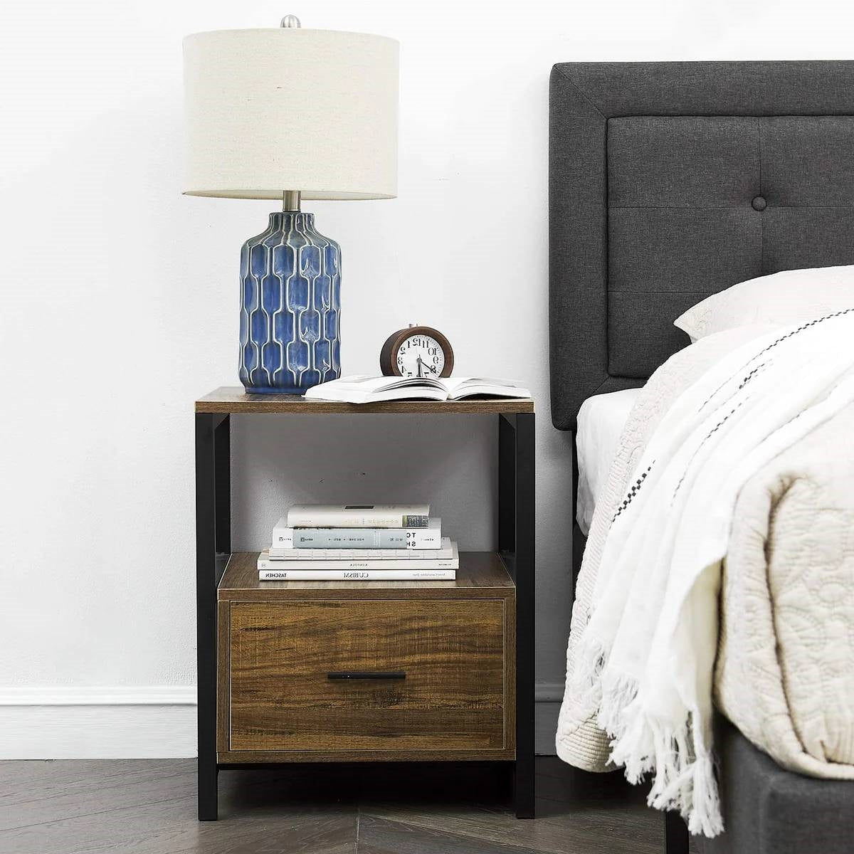 Set of 2 - Modern Metal Wood Side End Table Nightstand with Storage Drawer next to bed, featuring lamp and books on top.