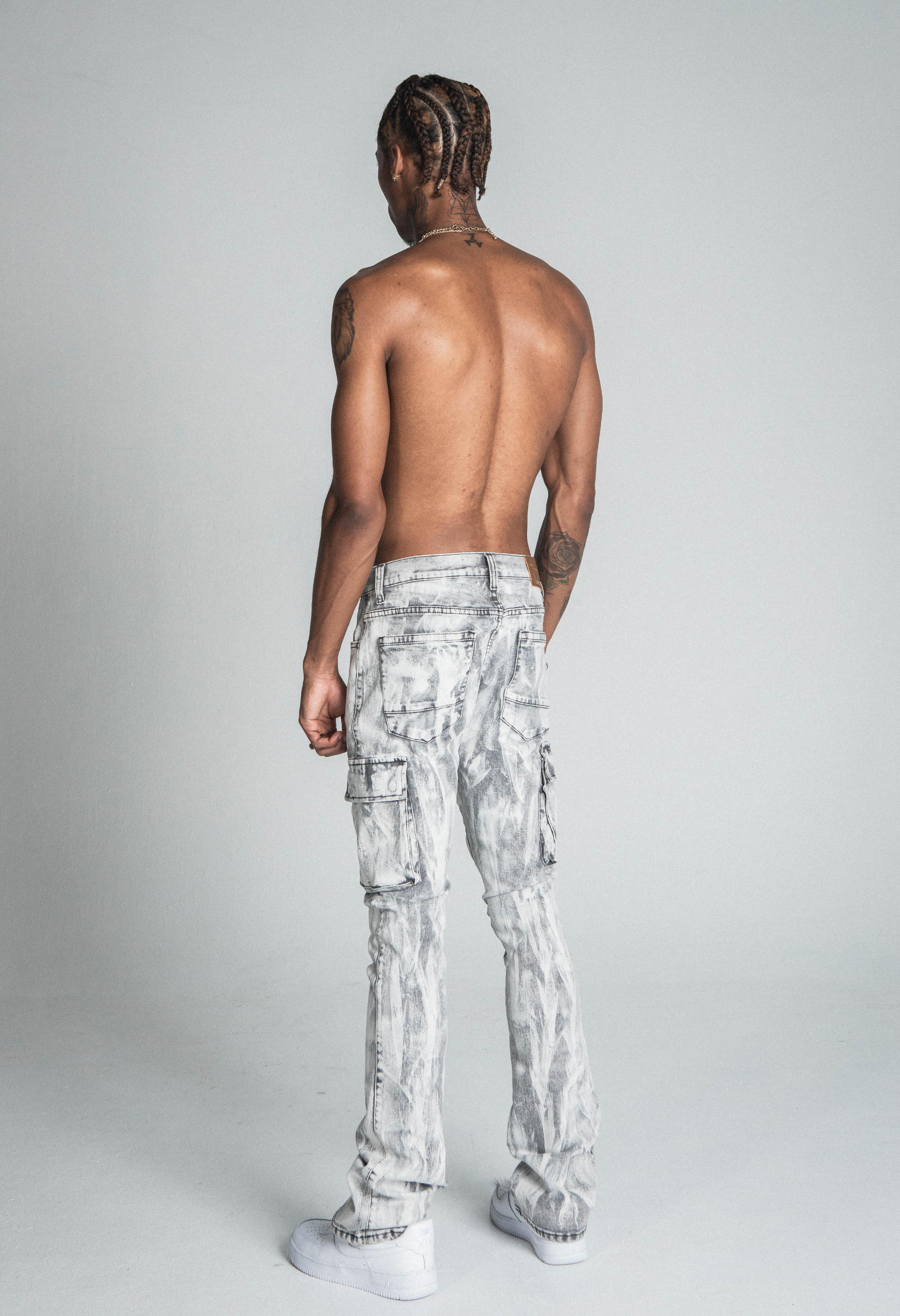 Model wearing AJ29SK GREY/WHITE WASH STACKED CARGO JEANS with paint splatter, cargo pockets, mid-rise waist, and stretchy cotton fabric.
