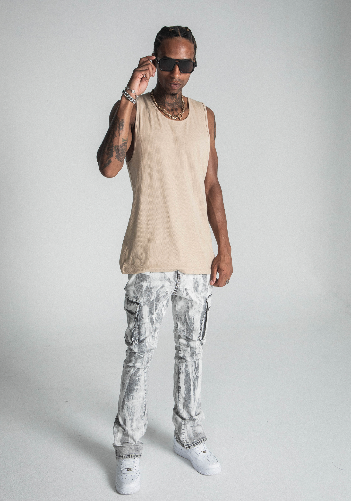 Model wearing AJ29SK GREY/WHITE WASH STACKED CARGO JEANS with splash paint design, mid rise waist, and cargo pockets.