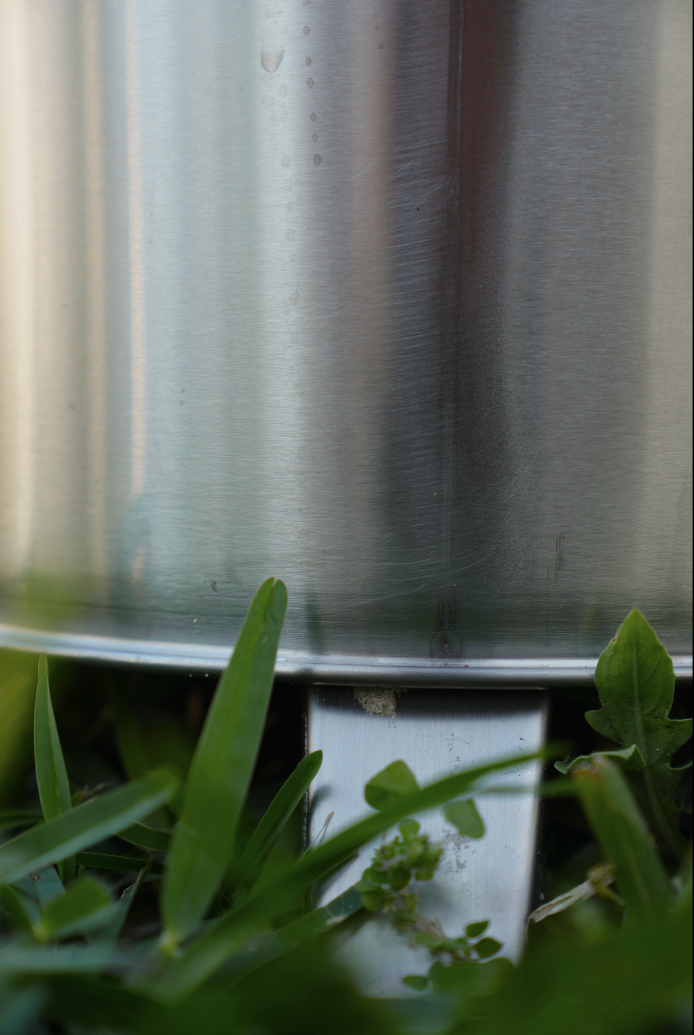 Small Smokeless Fire Pit standing outdoors on grass, showcasing stainless steel finish, ideal for post-sauna relaxation