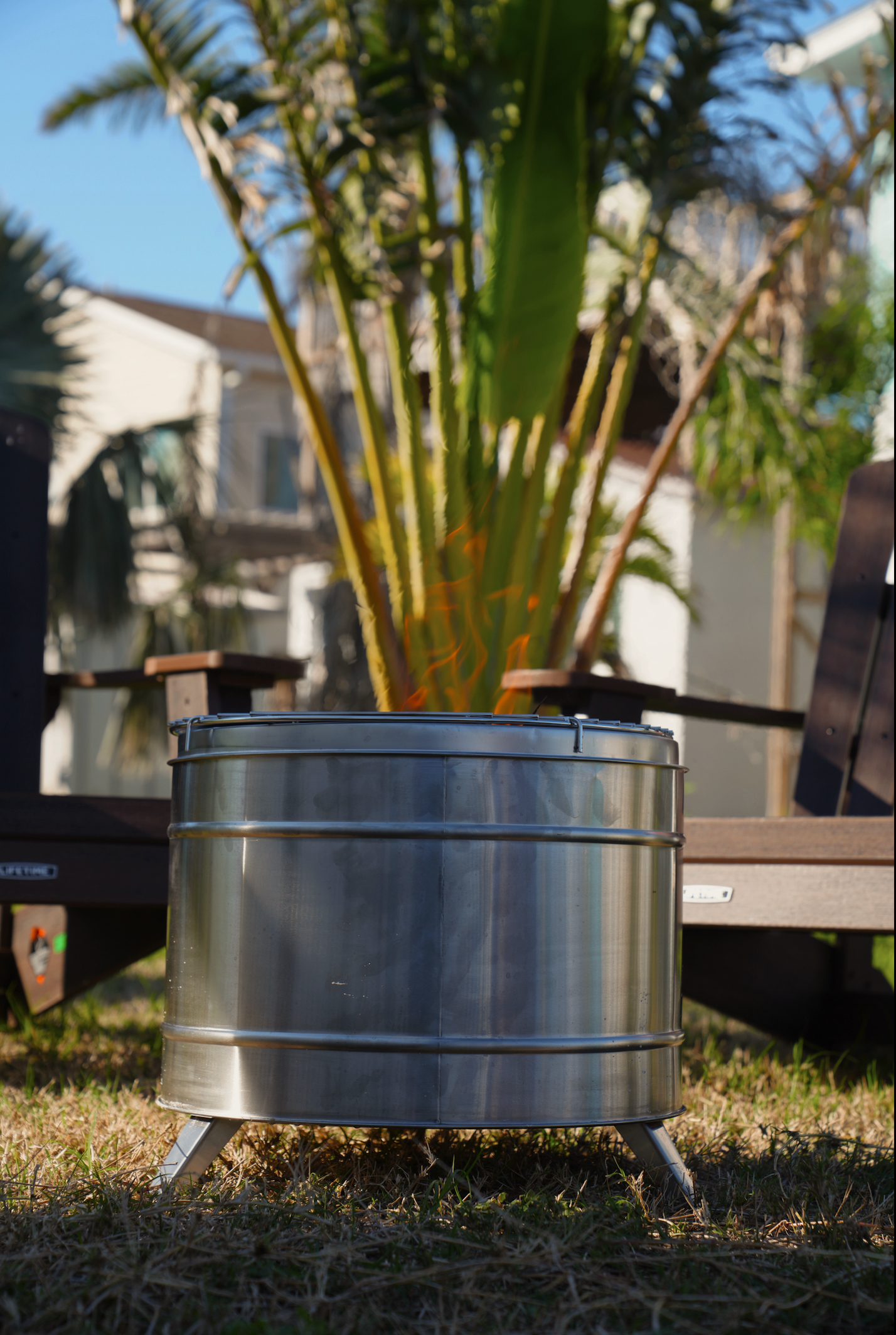 Large Smokeless Fire Pit outdoors with palm trees, ideal for relaxing post-sauna moments.