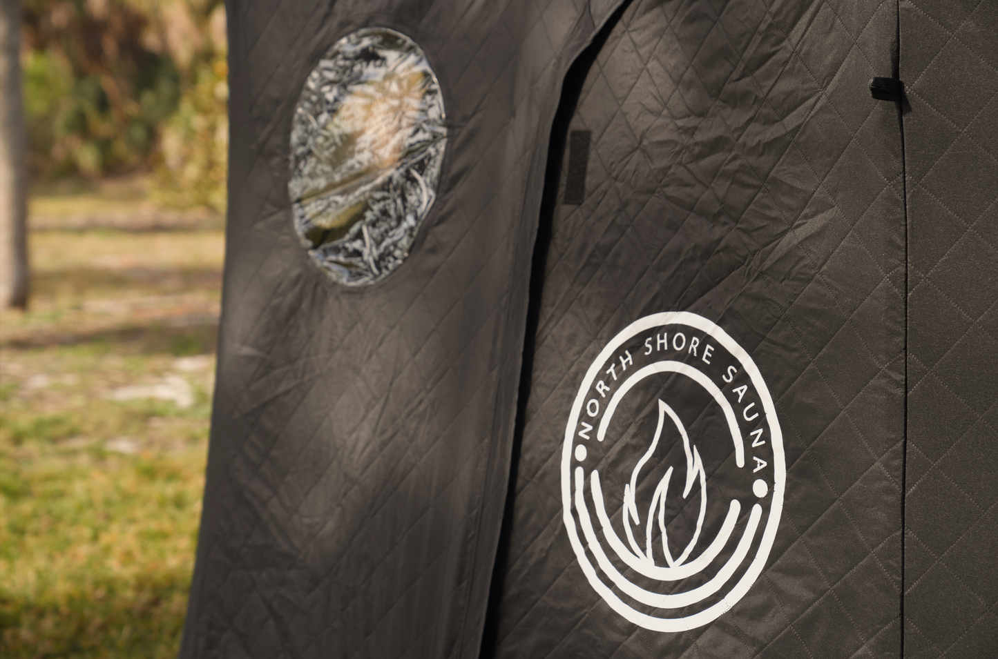 Close-up of Dome Sauna Tent (8-person; tent only) featuring logo and window, ideal for outdoor sauna experiences and gatherings.