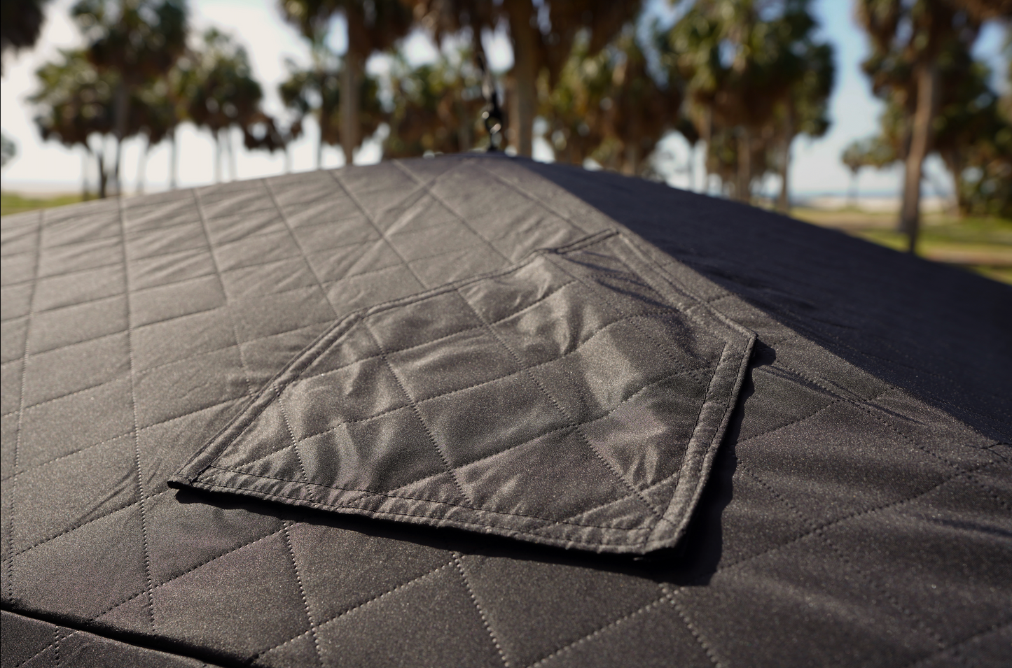 Top view of Mini Cube Sauna Tent (2-person; tent only) set up outdoors, showcasing its durable design among palm trees.