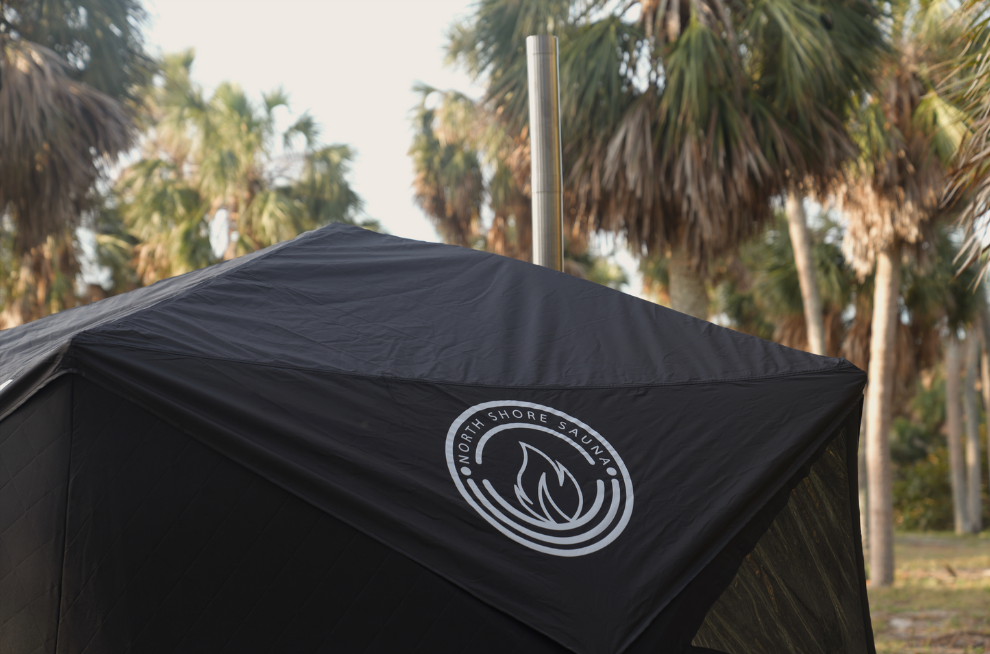Nova 6 Sauna Tent Starter Package (6-person) set up outdoors with palm trees.