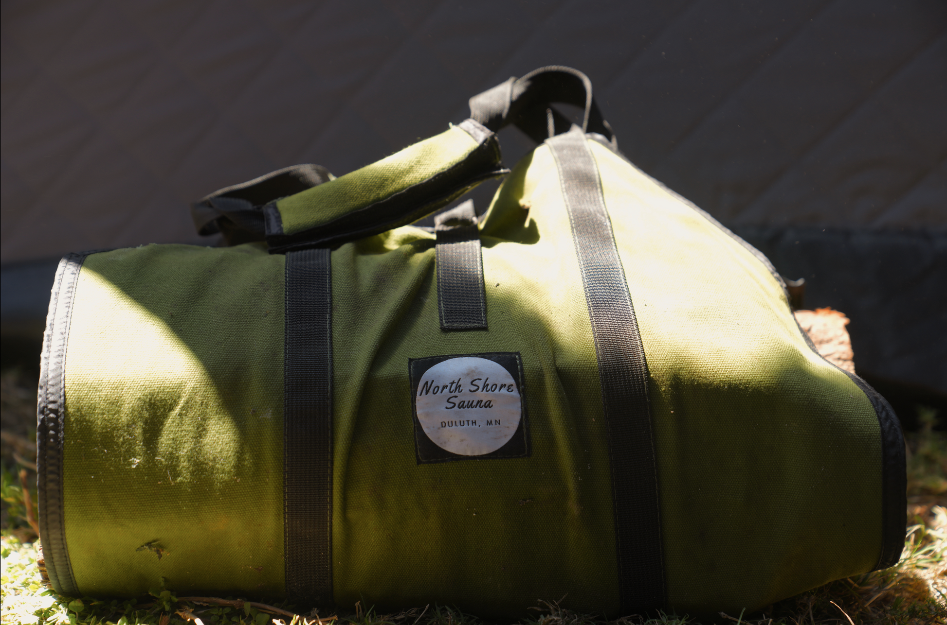 Green duffel bag included in Nova 6 Sauna Tent Elite Experience Package (6-person) showcasing premium portable sauna accessories.