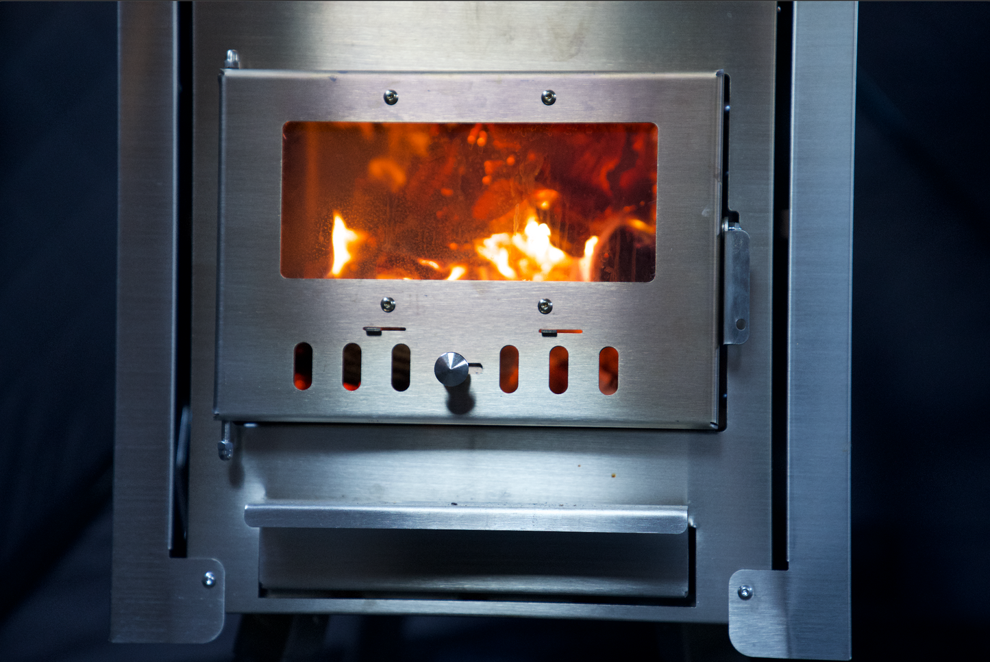 Close-up of blazing fire inside Sauna Tent Wood Stove XL with stainless-steel construction, for ultimate relaxation and steam generation.