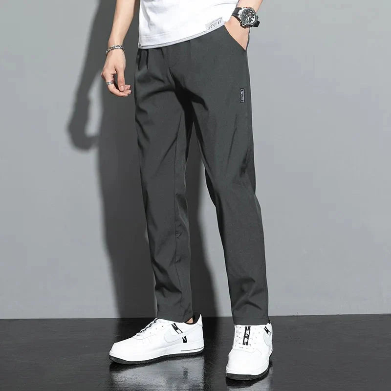 Man wearing slim fit stretch jogger pants with elastic waist in gray for casual style and comfort.