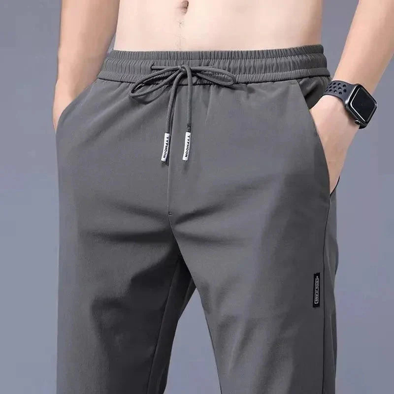 Model wearing gray Slim Fit Stretch Jogger Pants with Elastic Waist for men.