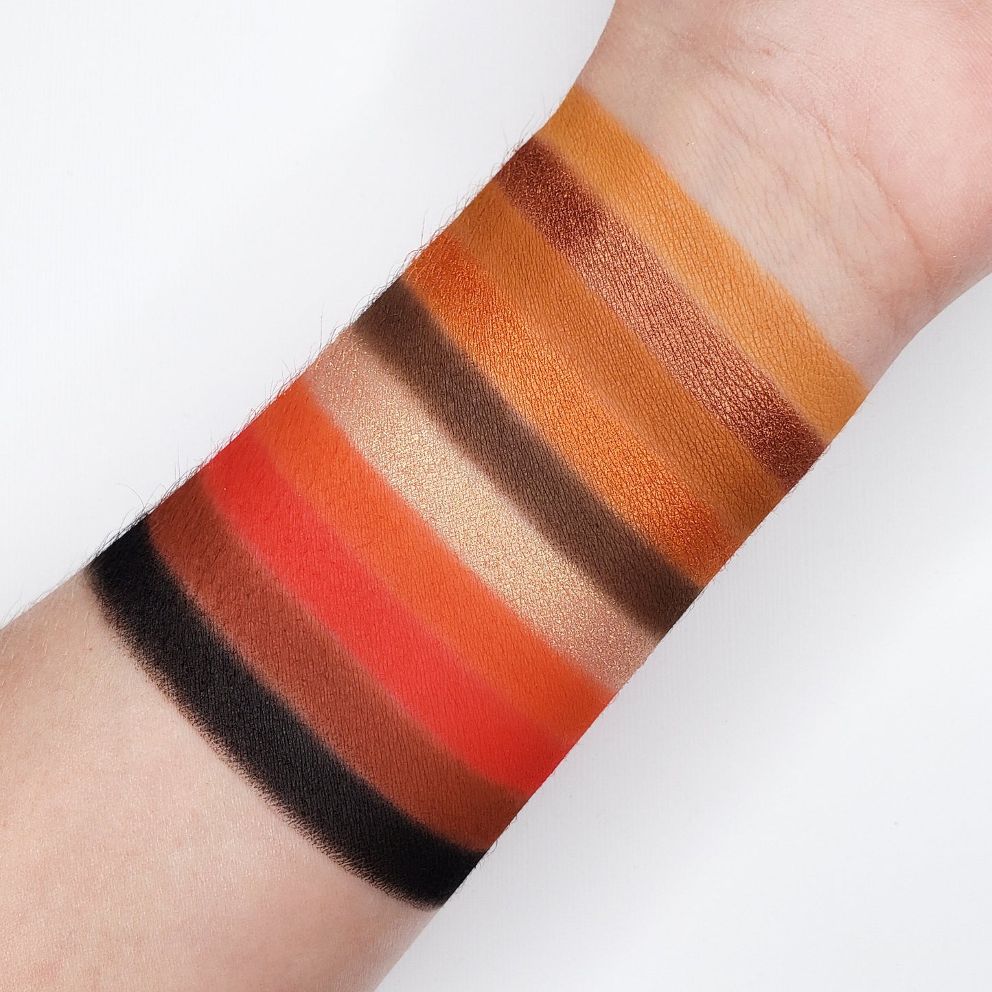 Swatches of 10 Color Temptation Eyeshadow Collection SN10 showcasing ten pigmented warm shades on an arm.