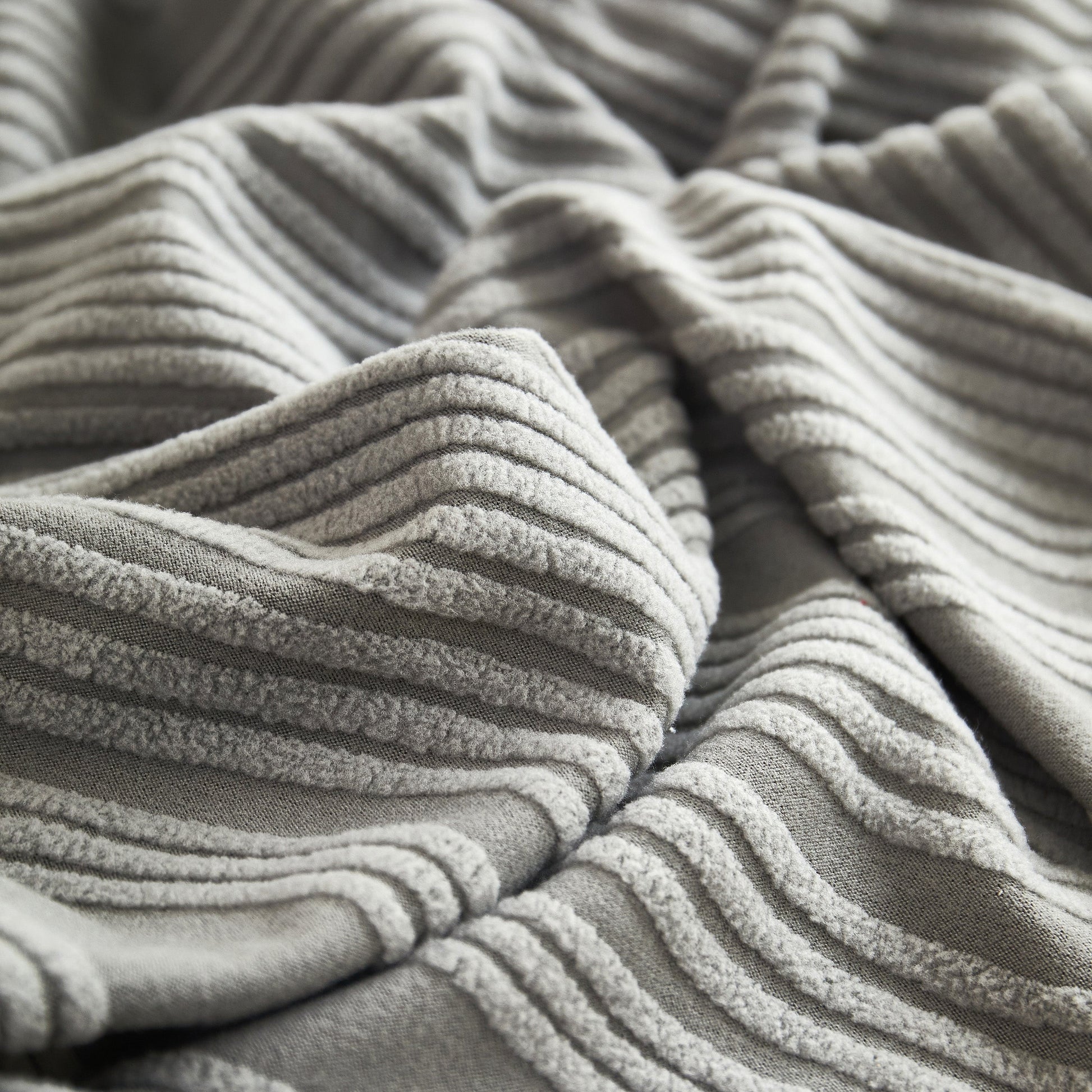 Close-up of the Textured Wave Stretch Sofa Couch Cover fabric showcasing soft, washable spandex slipcover with elegant wave pattern.