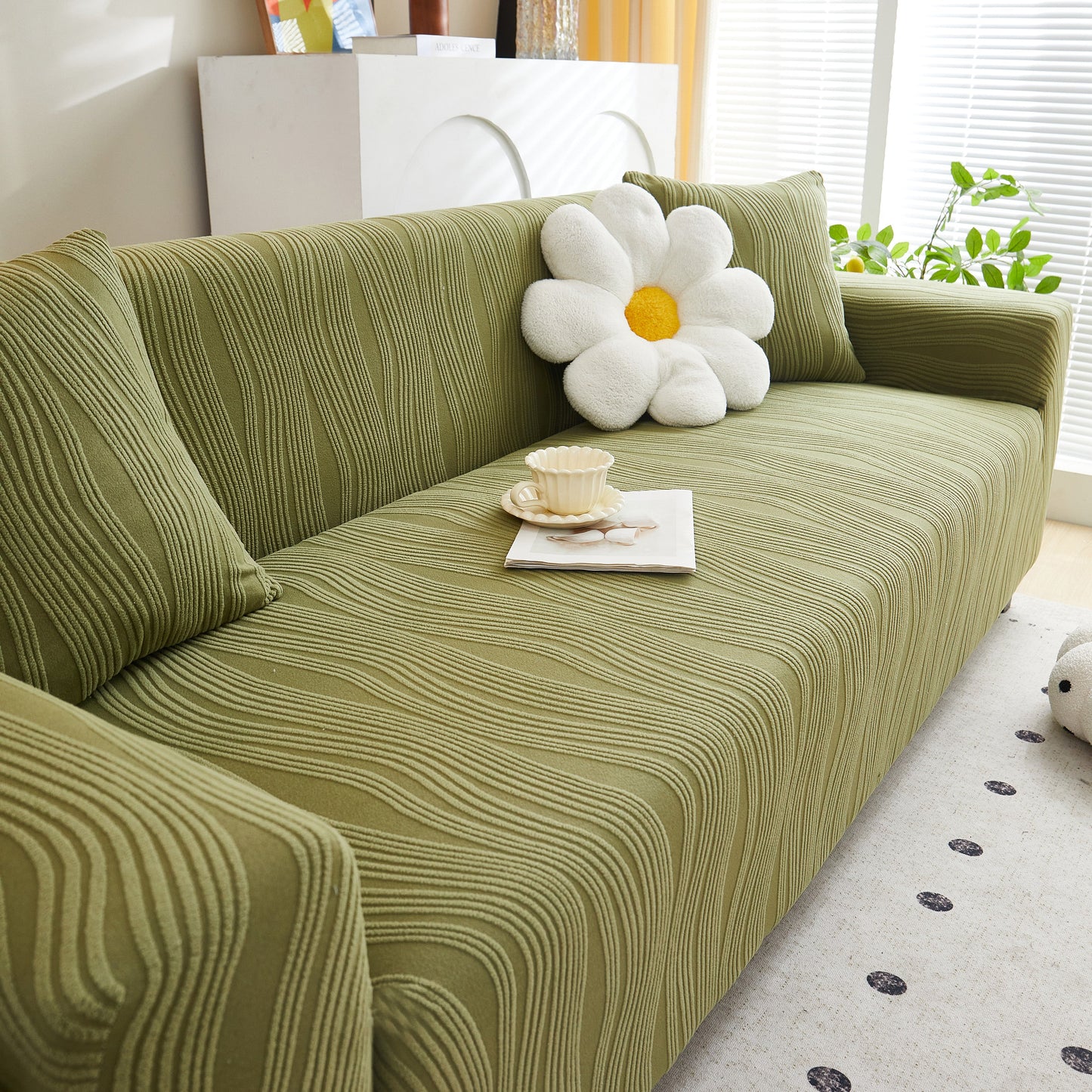 Textured Wave Stretch Sofa Couch Cover, Soft Washable Spandex Furniture Slipcovers on green couch with flower pillow.