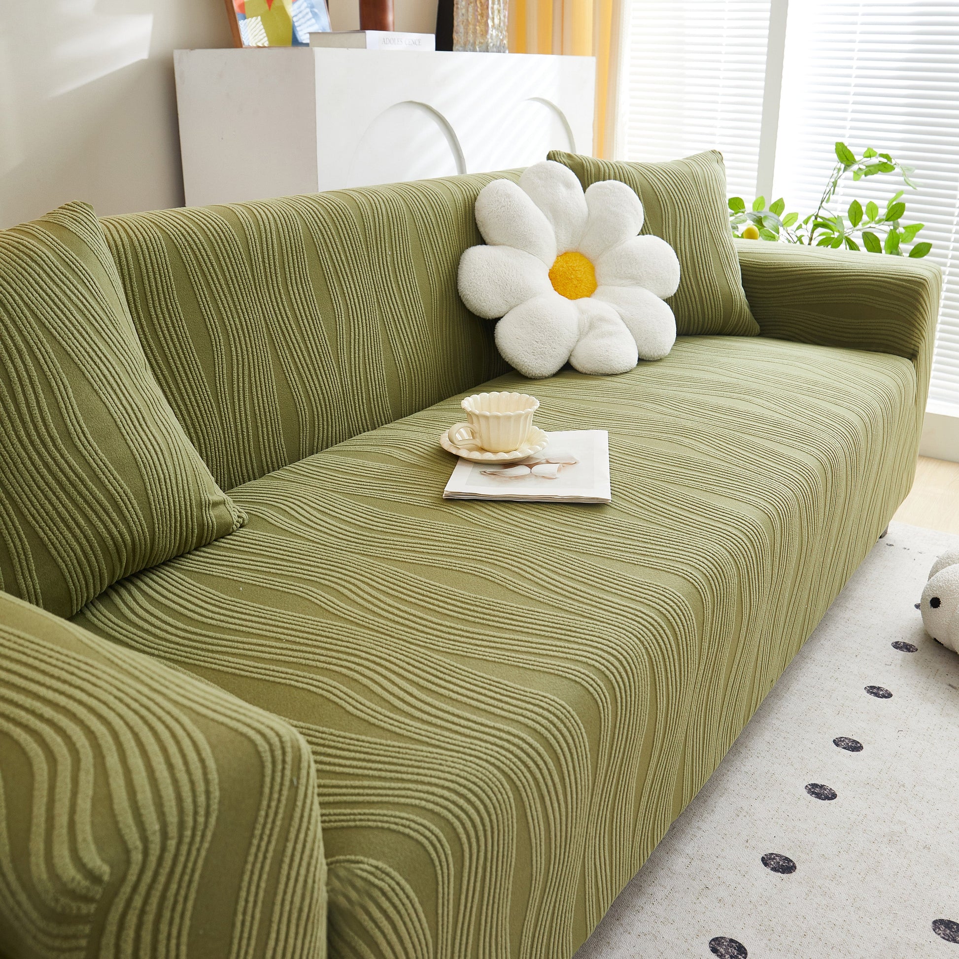 Textured Wave Stretch Sofa Couch Cover, Soft Washable Spandex Furniture Slipcovers on green couch with flower pillow.