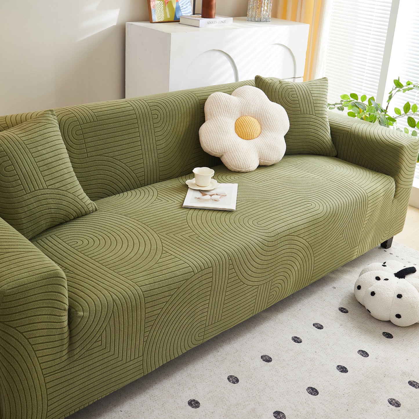 Green sofa with Fleece Stretch Sofa Slipcover Washable Soft Spandex Couch Cover Furniture Protector and decorative pillows in a living room.