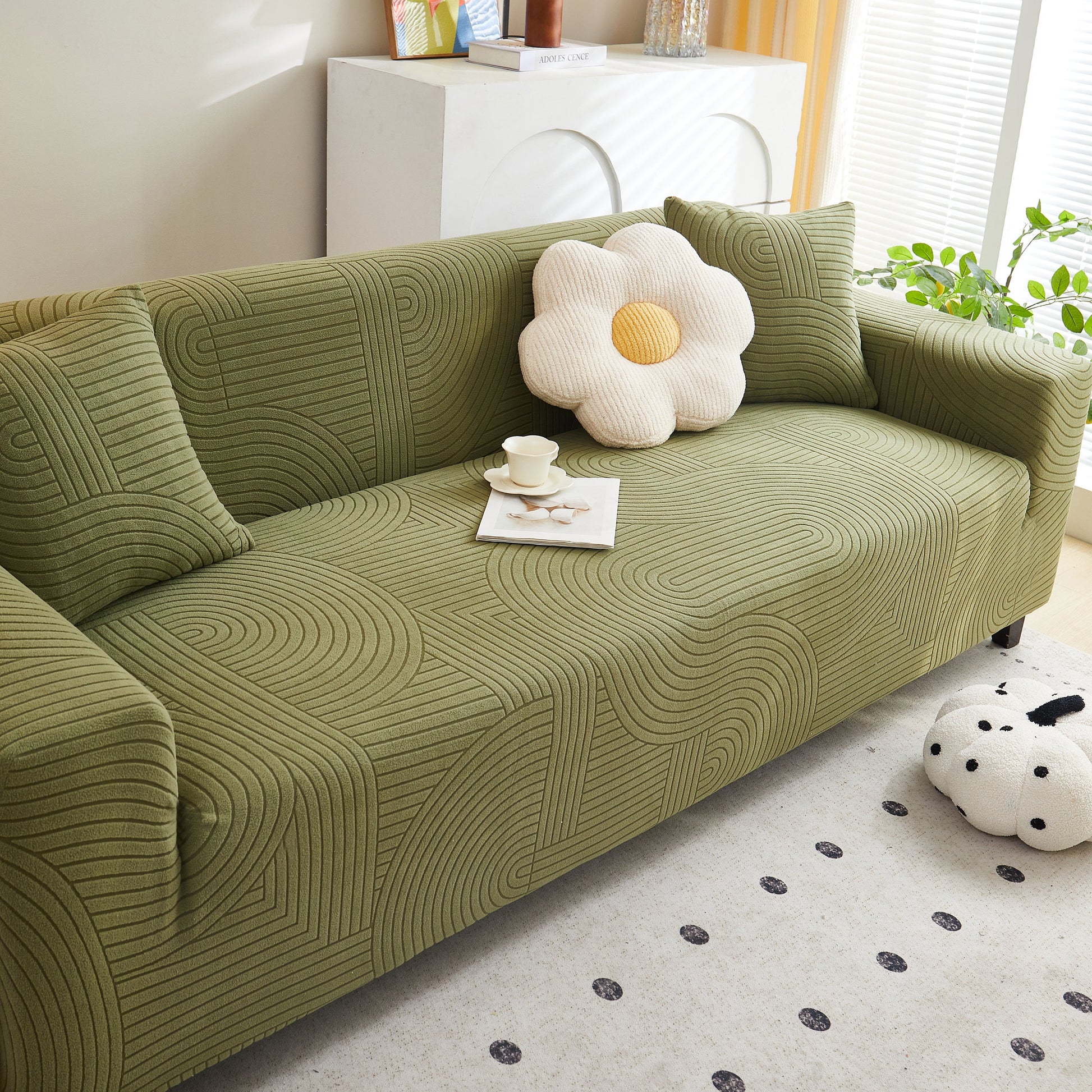 Green sofa with Fleece Stretch Sofa Slipcover Washable Soft Spandex Couch Cover Furniture Protector and decorative pillows in a living room.