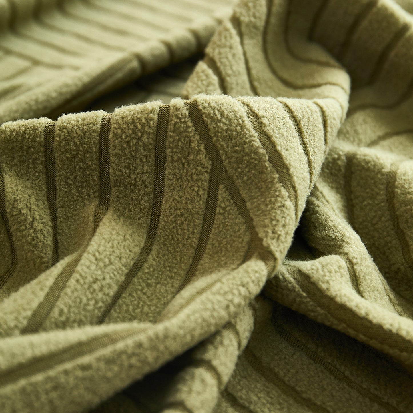 Close-up of green Fleece Stretch Sofa Slipcover Washable Soft Spandex Couch Cover Furniture Protector showing geometric wave pattern.