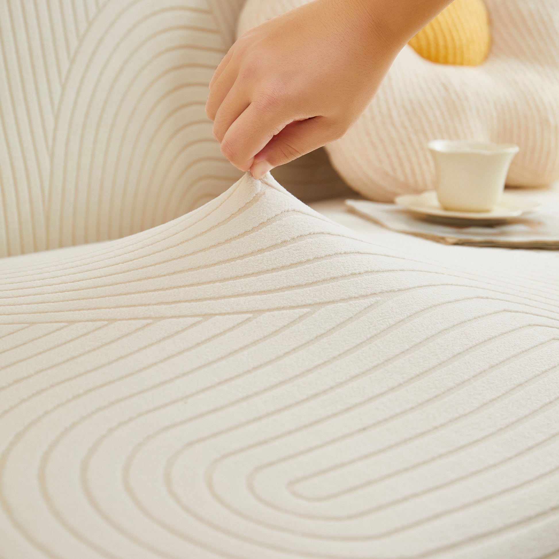 Close-up of Fleece Stretch Sofa Slipcover Washable Soft Spandex Couch Cover with geometric wave pattern being adjusted