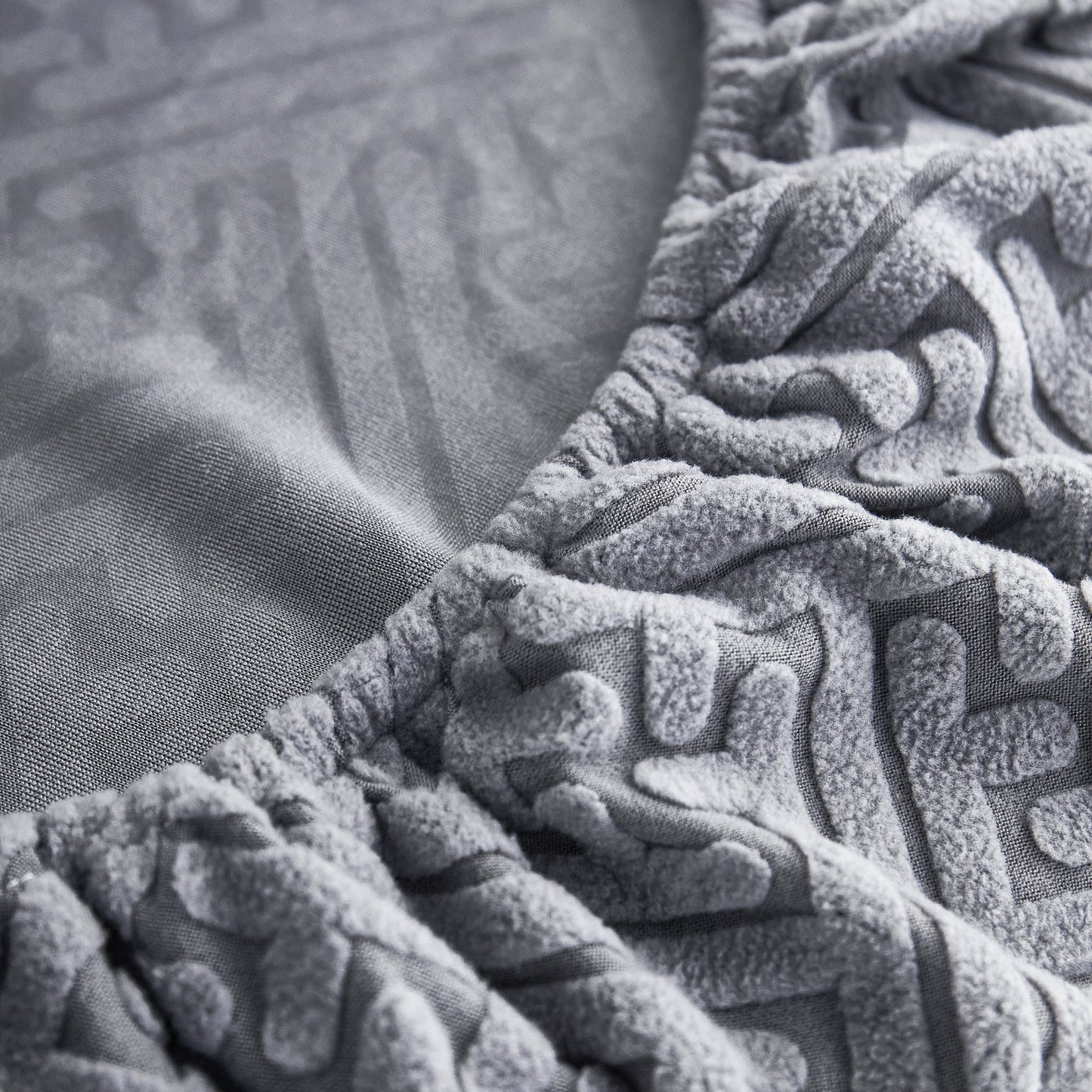 Close-up of Stretch Sofa Seat Cushion Cover in gray polar fleece with elastic edge, ideal for pet and kid protection.