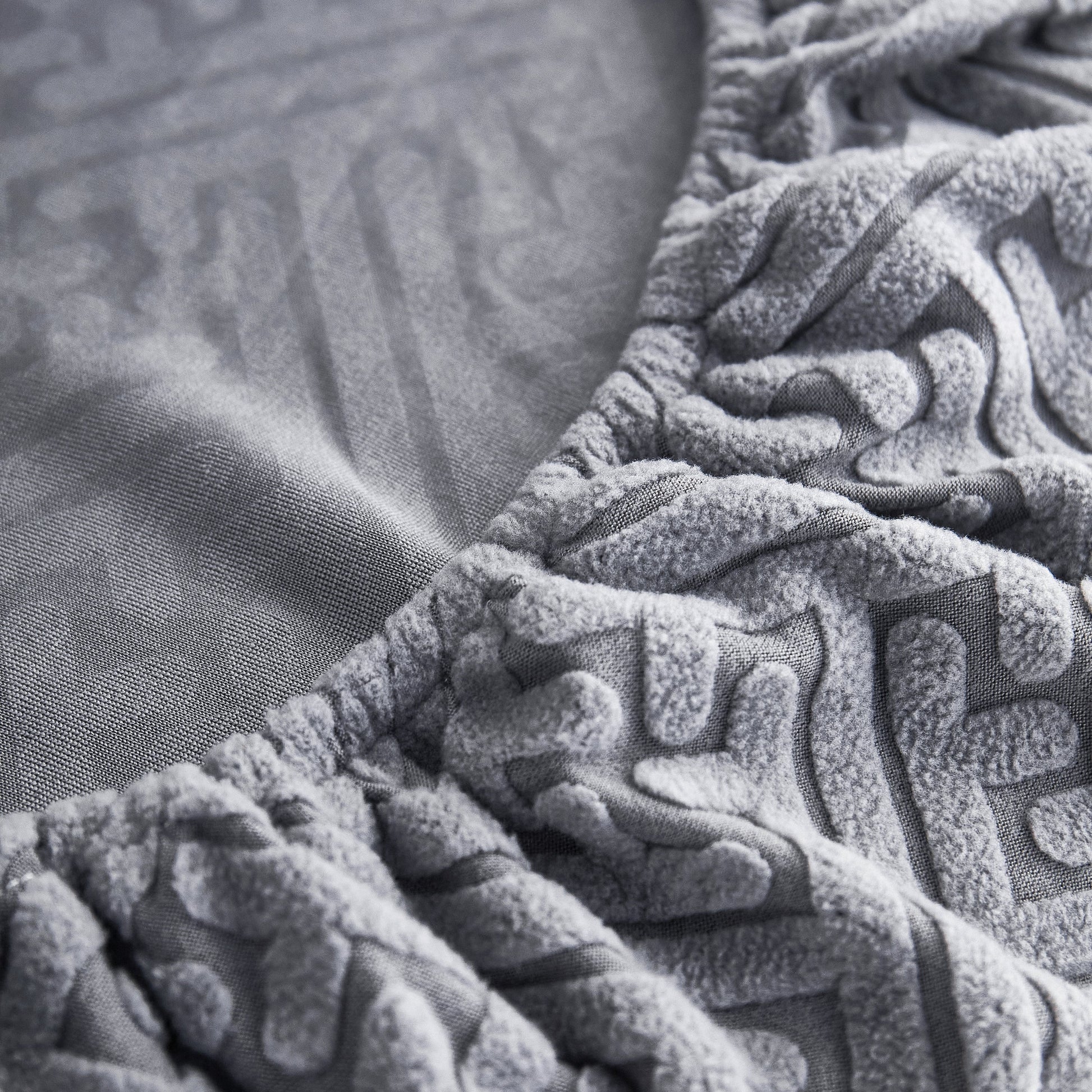 Close-up of Stretch Sofa Seat Cushion Cover in gray polar fleece with elastic edge, ideal for pet and kid protection.