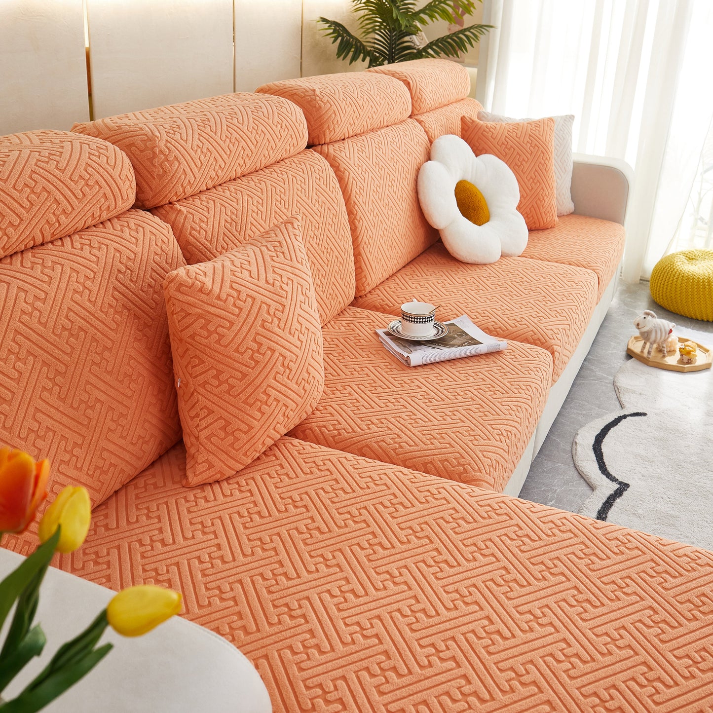 Stylish orange sofa with Polar Fleece Couch Cushion Covers, featuring a plush flower pillow and cozy living room setting.
