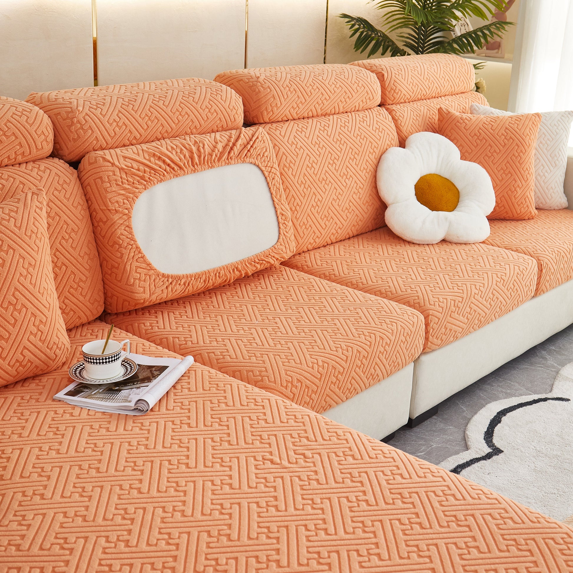 Polar Fleece Couch Cushion Covers on sofa, Elastic Furniture Protector for Pets, Kid in orange with stylish pattern.