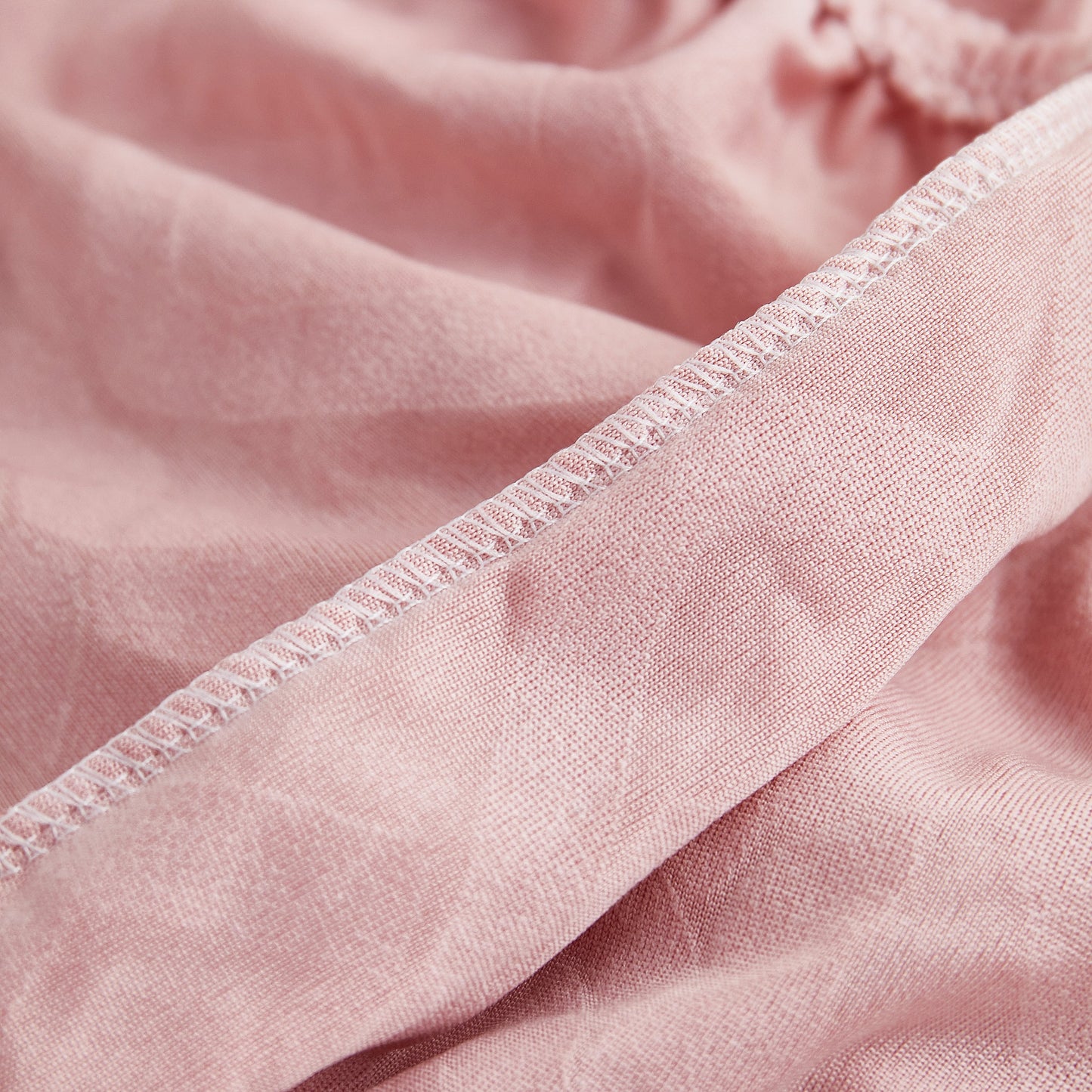 Close-up of Stretch Couch Seat Cushion Covers, Sofa Slipcover Sofa Cover Soft Flexibility with Elastic Bottom in pink fabric.