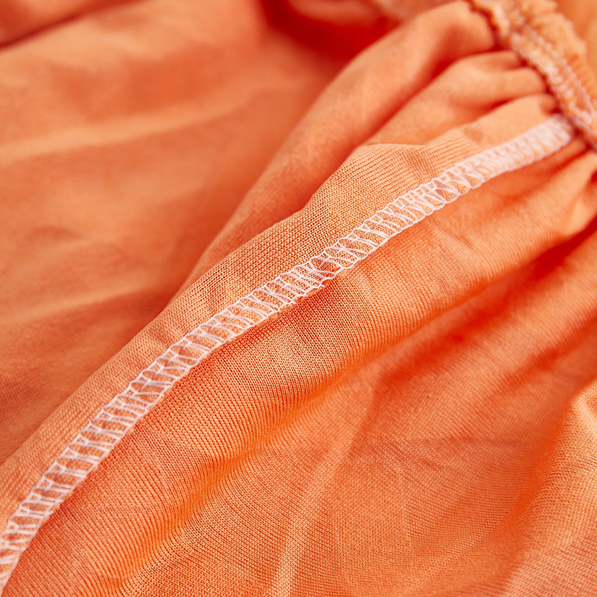 Close-up of orange fabric with elastic bottom, part of Stretch Couch Seat Cushion Covers, Sofa Slipcover Sofa Cover Soft Flexibility
