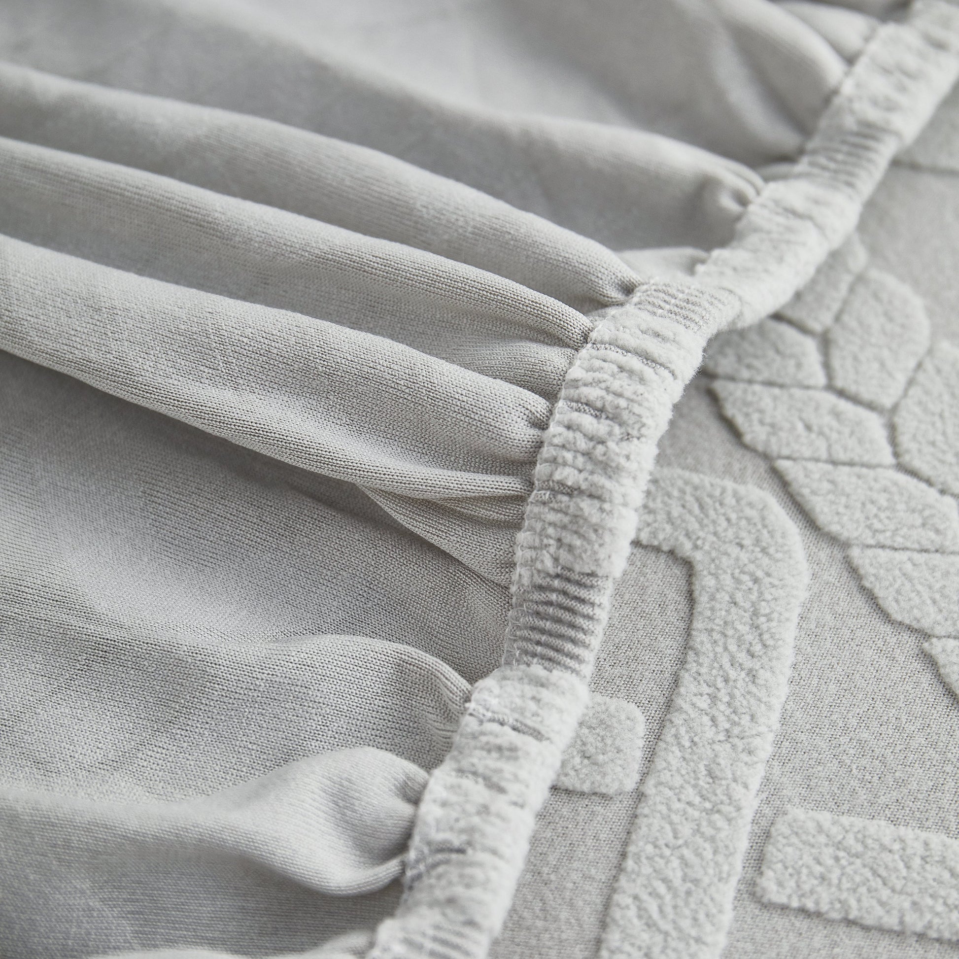 Close-up of Stretch Couch Seat Cushion Covers, Sofa Slipcover Sofa Cover Soft Flexibility with Elastic Bottom detail in grey fabric.