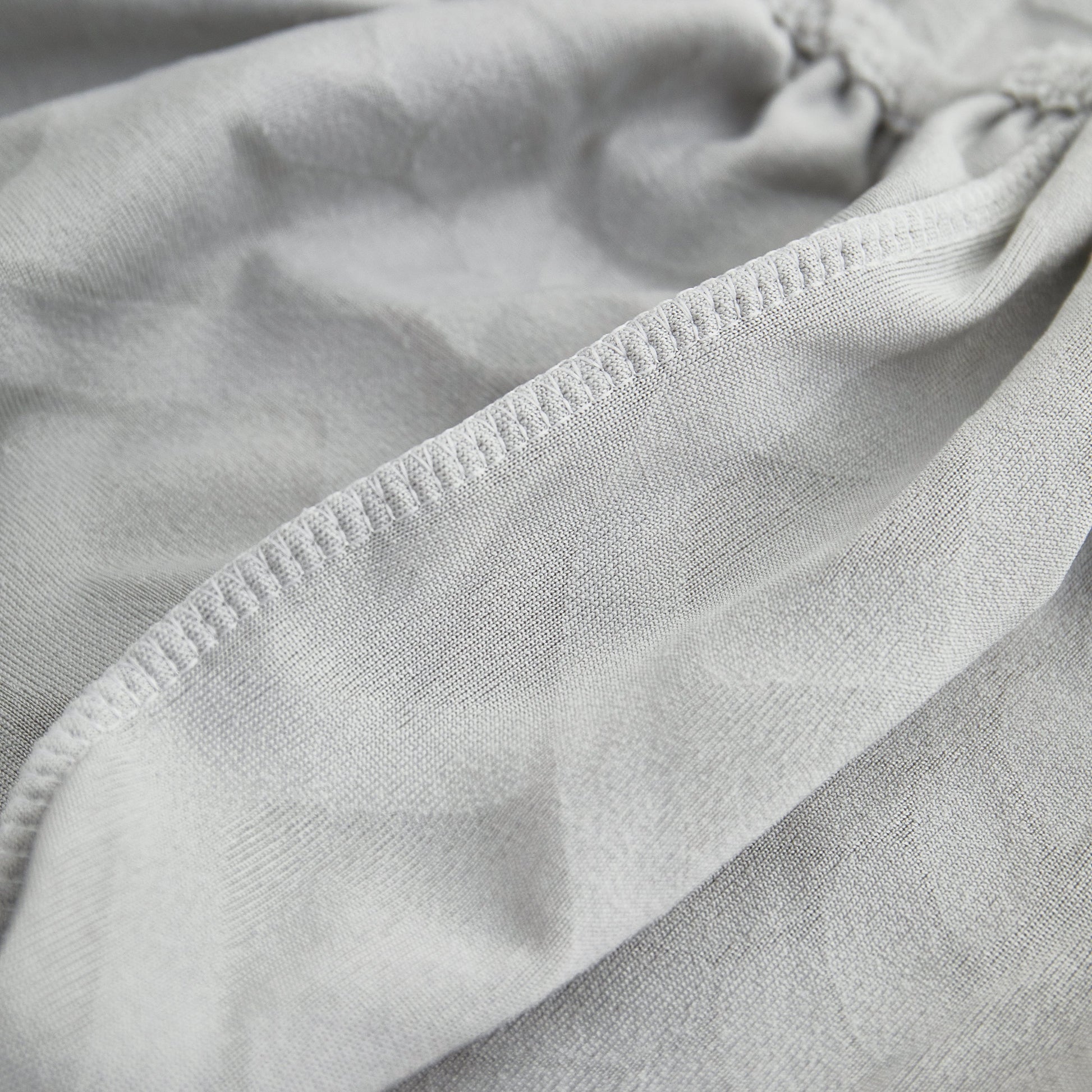 Close-up of Stretch Couch Seat Cushion Covers, Sofa Slipcover Sofa Cover Soft Flexibility with Elastic Bottom in grey fabric.