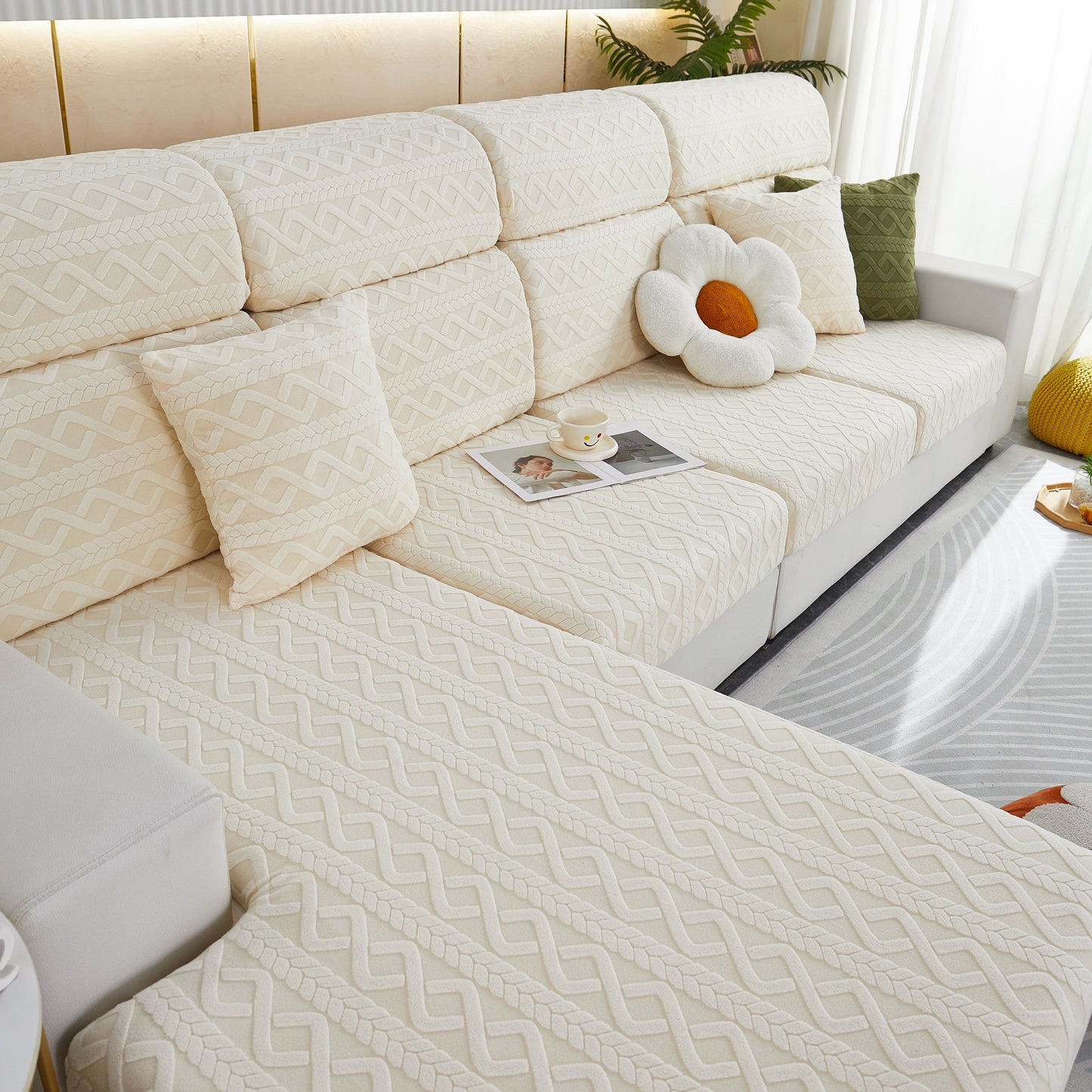 Stylish white couch with pattern, adorned with pillows, in a bright living room.