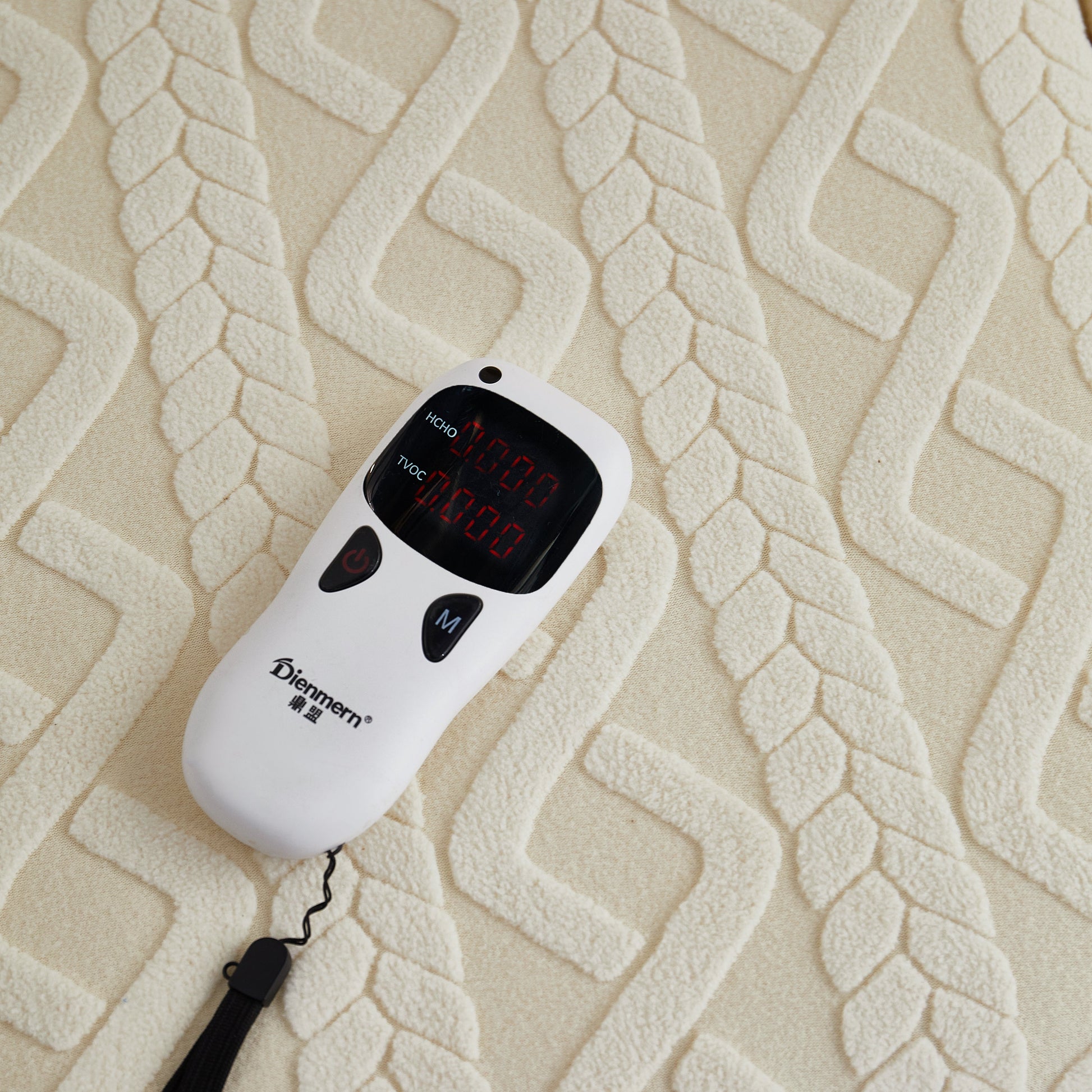 Close-up of white electronic gadget on patterned fabric surface.