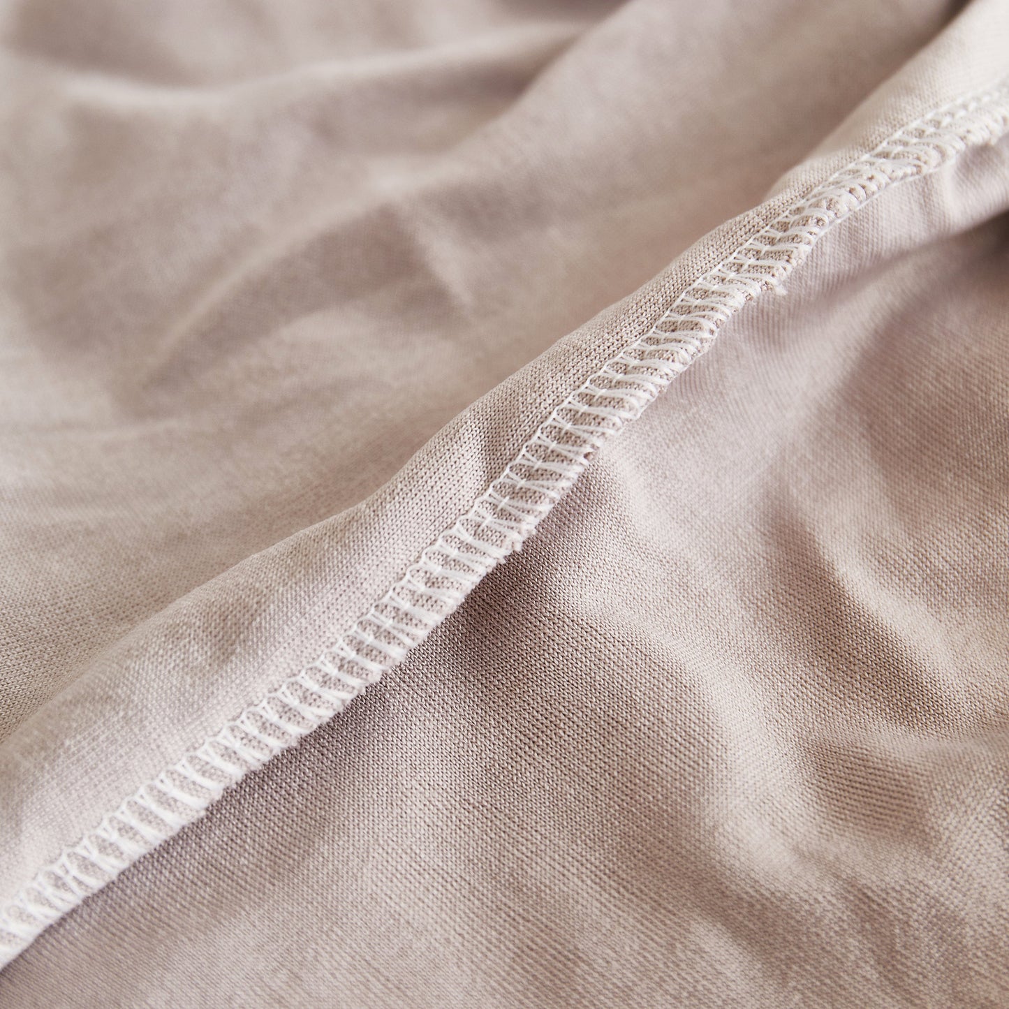 Close-up of a beige fabric showing seam and texture, ideal for concepts related to textiles and material quality.