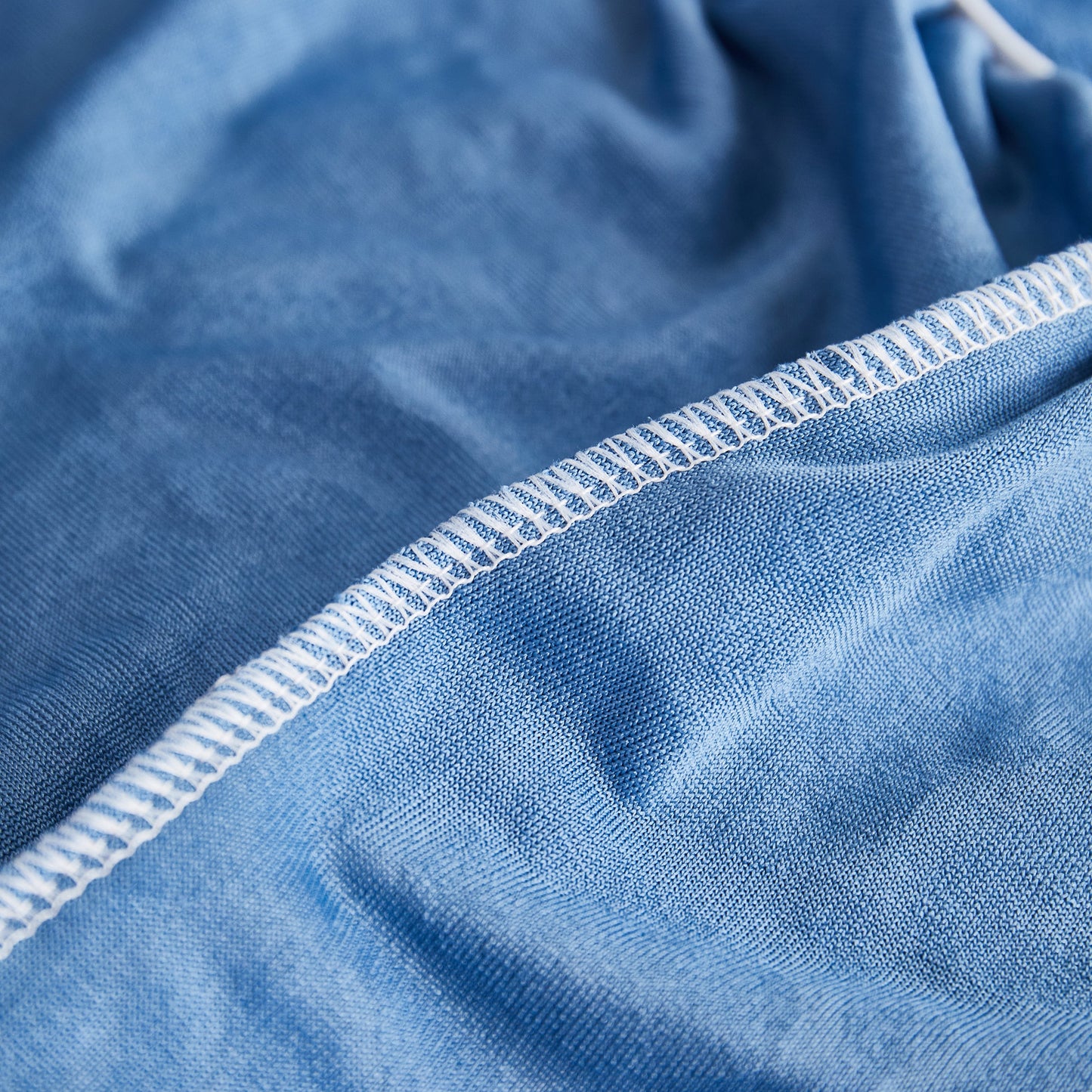 Close-up of durable stitching on a blue fabric from the Sofa Seat Cover, Sunflower Patterned Elastic Skirted Couch Cushion Covers for 1/2/3/4-Seater Sofas.