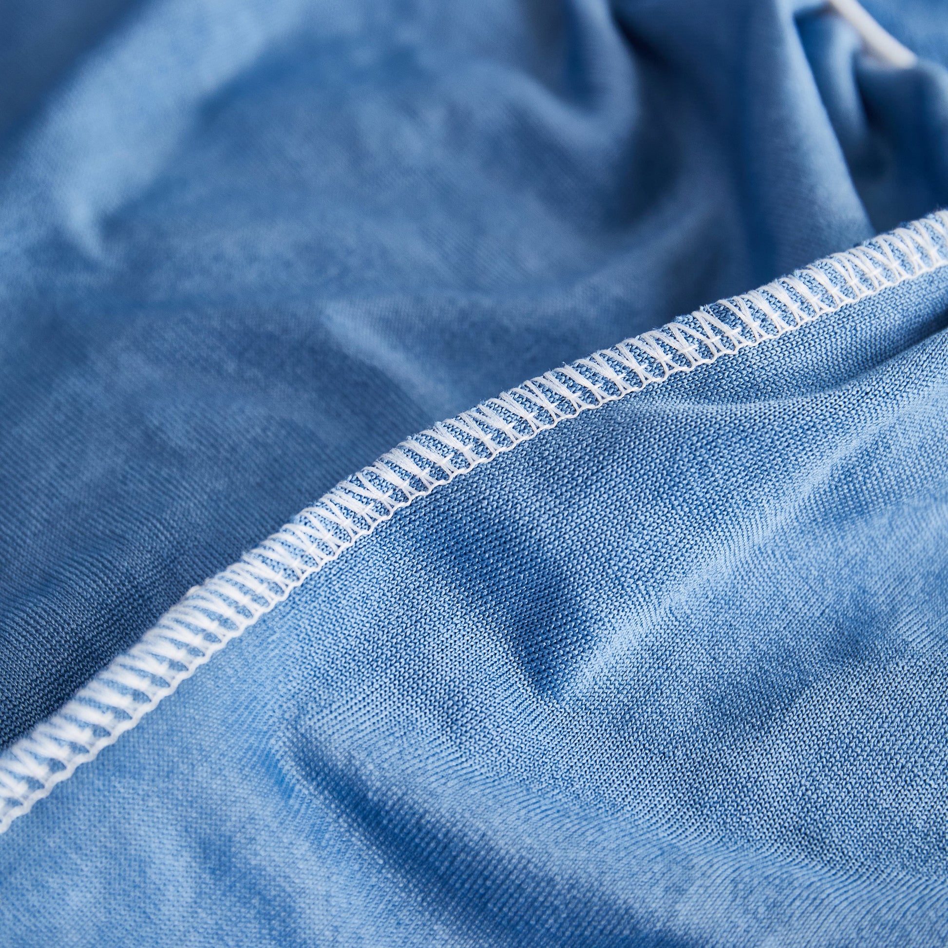 Close-up of durable stitching on a blue fabric from the Sofa Seat Cover, Sunflower Patterned Elastic Skirted Couch Cushion Covers for 1/2/3/4-Seater Sofas.