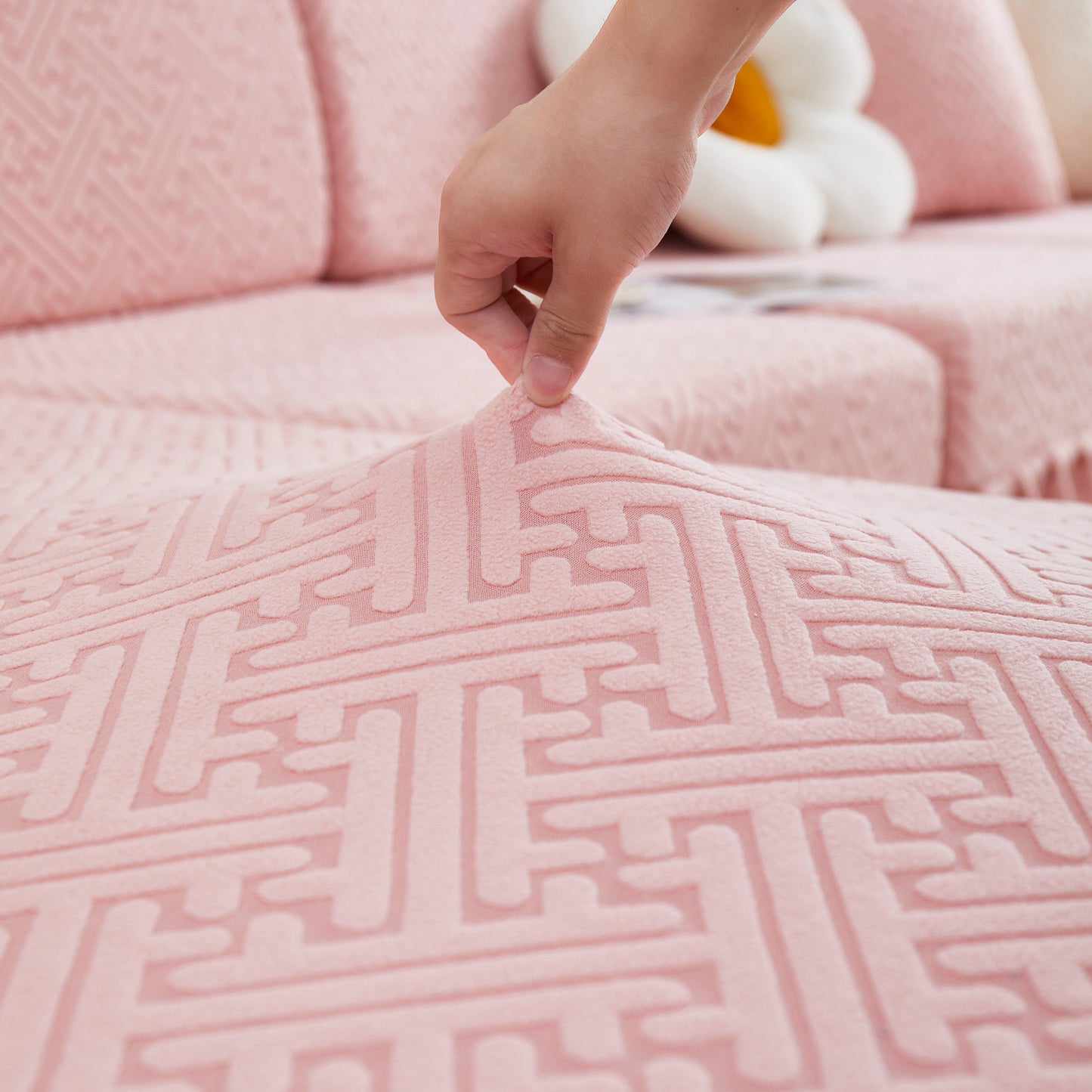 Close-up of pink Stretch Sofa Covers with Skirt for Couch Seat and Cushion, Chaise, Sectional, 1/2/3/4 Seater Sofas being adjusted