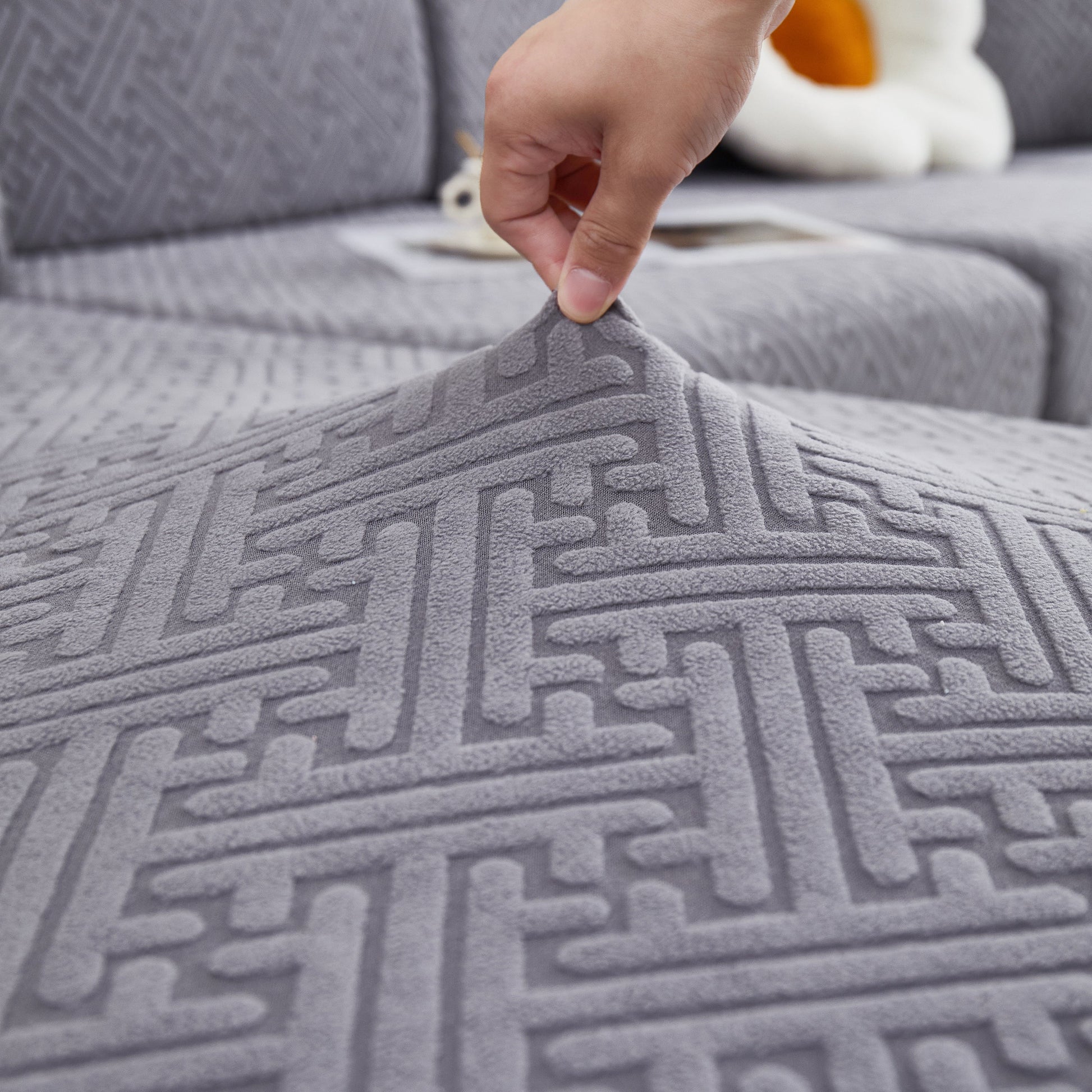 Close-up of Stretch Sofa Covers with Skirt for Couch Seat and Cushion, Chaise, Sectional, 1/2/3/4 Seater Sofas in grey fabric texture.