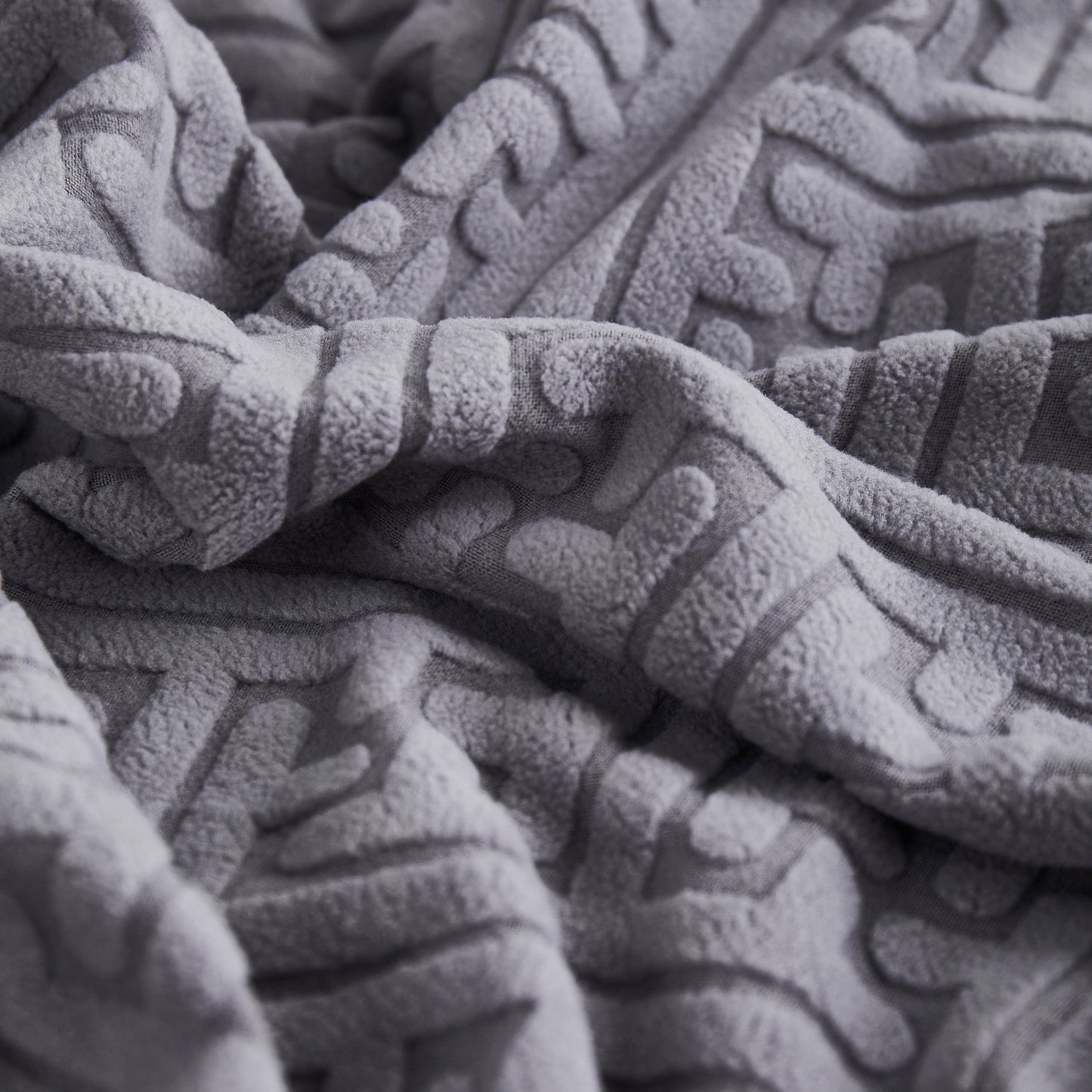 Close-up of gray textured fabric used in stretch sofa covers with skirt for couch seat and cushion, chaise, sectional, 1/2/3/4 seater sofas.