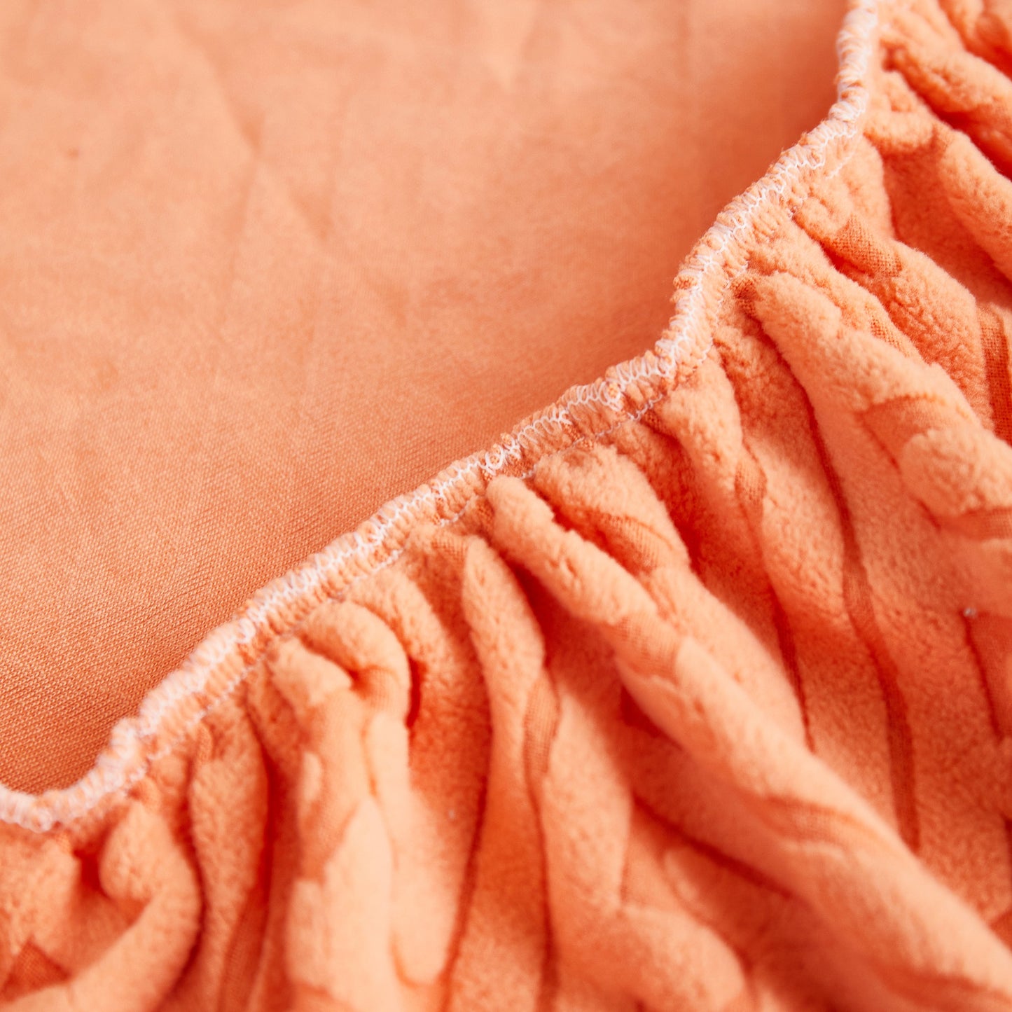 Close-up of Stretch Sofa Covers with Skirt for Couch Seat and Cushion, Chaise, Sectional, 1/2/3/4 Seater Sofas in orange fabric.