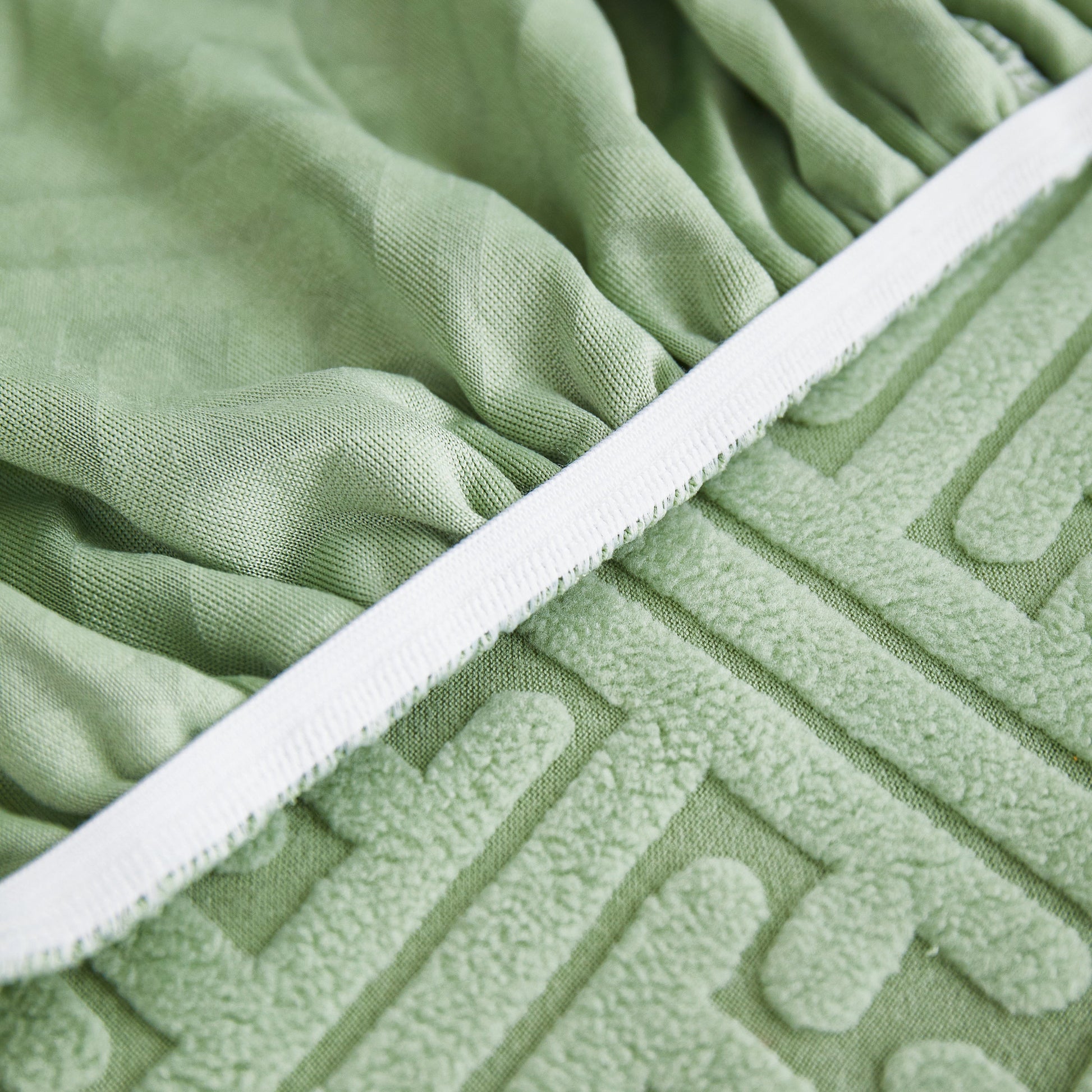 Close-up of green Stretch Sofa Covers with Skirt for Couch Seat and Cushion, Chaise, Sectional, 1/2/3/4 Seater Sofas