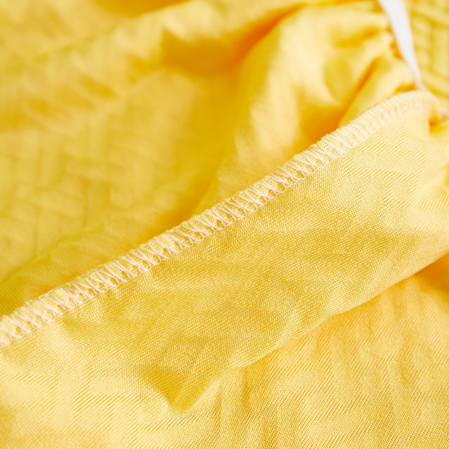 Close-up of high-quality polar fleece fabric for Tailored Sofa Cushion Covers Stretch Couch Seat Covers with Skirt for Sectional Sofas in yellow.