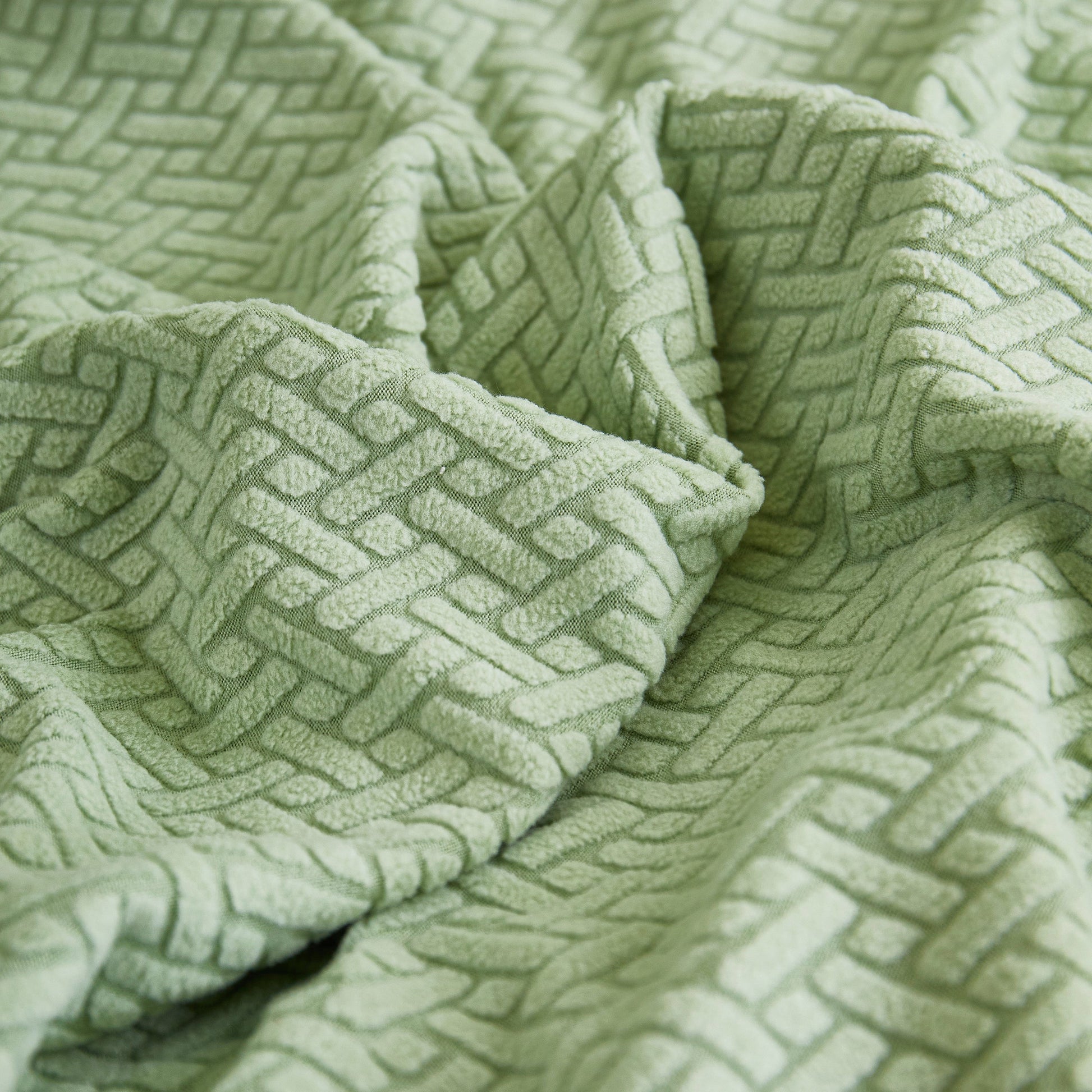 Close-up of textured green fabric for Tailored Sofa Cushion Covers Stretch Couch Seat Covers with Skirt for Sectional Sofas.