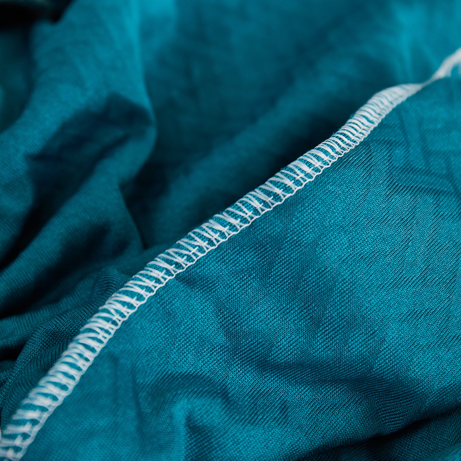 Close-up of blue fabric detail with stitching, showcasing the texture and quality of Tailored Sofa Cushion Covers Stretch Couch Seat Covers with Skirt for Sectional Sofas.