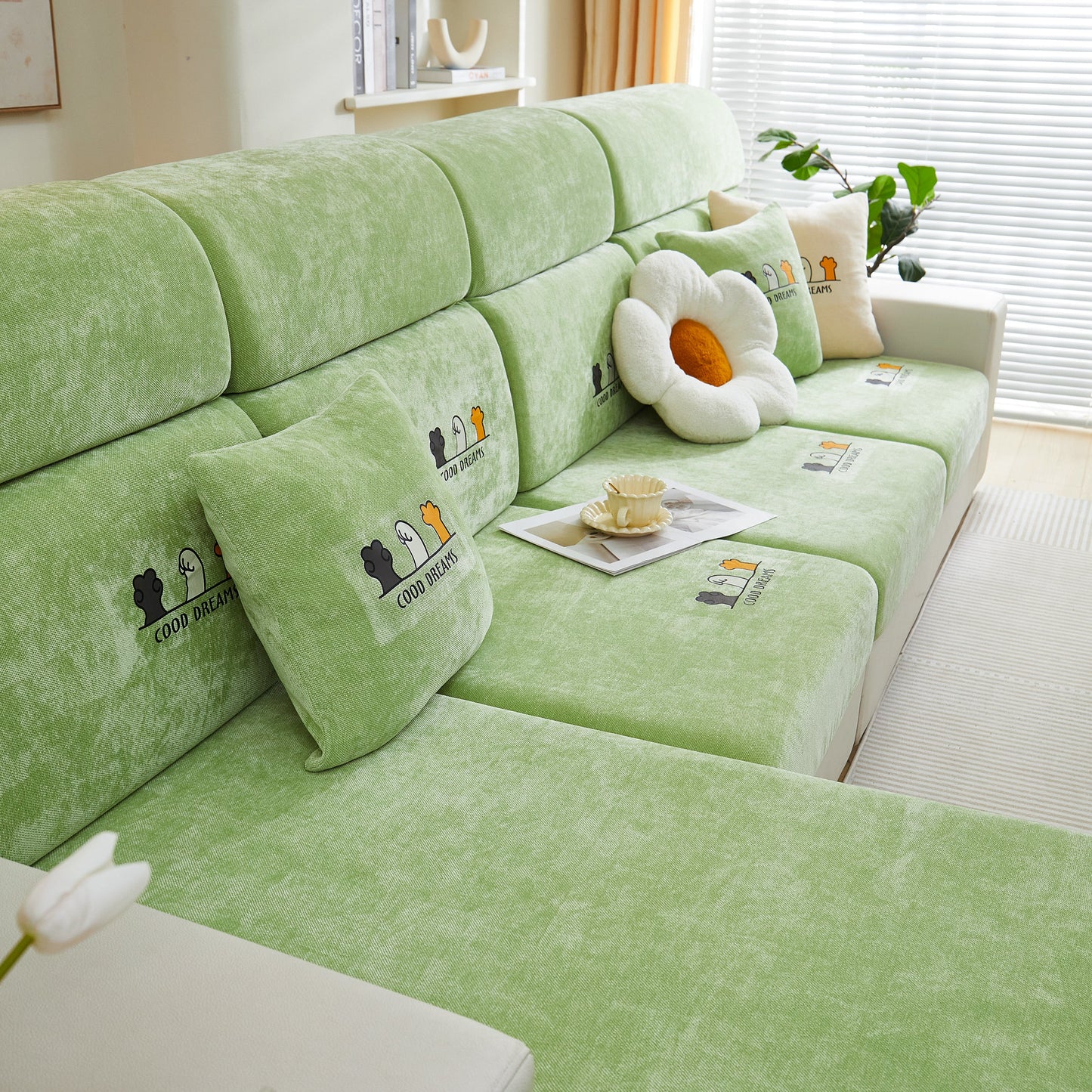 Super Stretch Seat Cushion/Couch Slipcover on green couch with decorative pillows, providing stylish protection and comfort.