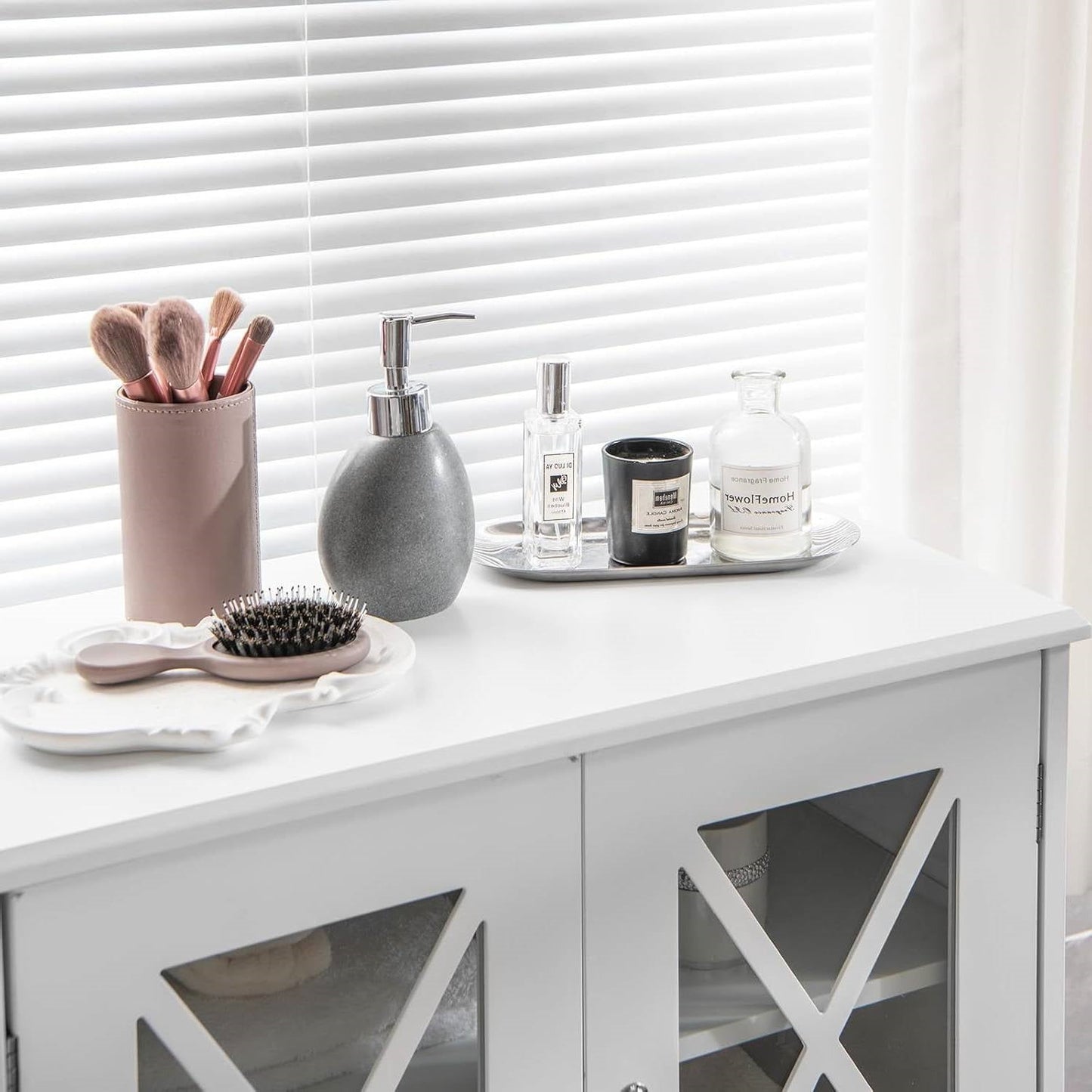 White Bathroom Towel Linen Cabinet with Glass Doors and Storage Shelves with toiletries on top.