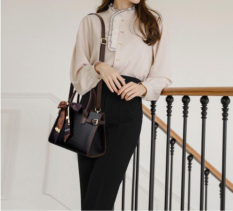 Woman with Serpent Luxe Snakeskin Handbag - Elegant Leather Commuter Bag for Stylish Women, on a staircase.
