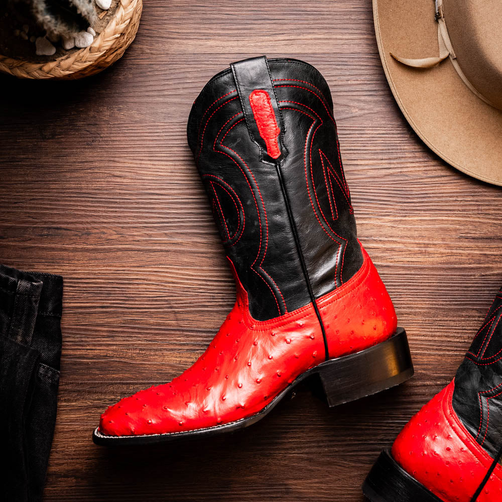 Alabama Red genuine ostrich skin cowboy boot displaying vibrant Western style on a wooden floor.