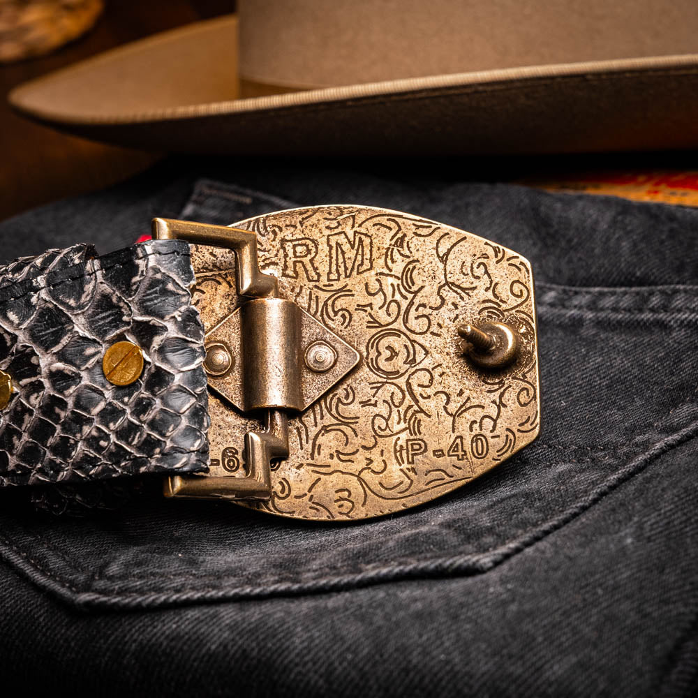 Arkansas Belt Antique Newspaper with genuine python skin and brass buckle on denim background